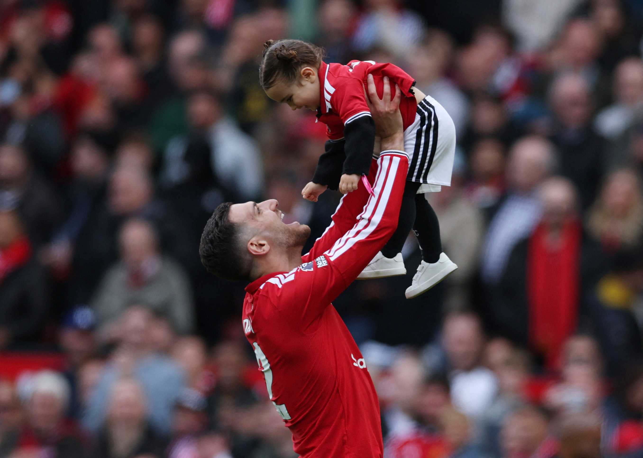 Soccer Football - Premier League - Manchester United v Nottingham Forest - Old Trafford, Manchester, Britain - May 17, 2026 Manchester United's Diogo Dalot with his daughter Clara on the pitch at the end of the match REUTERS/Phil Noble EDITORIAL USE ONLY.