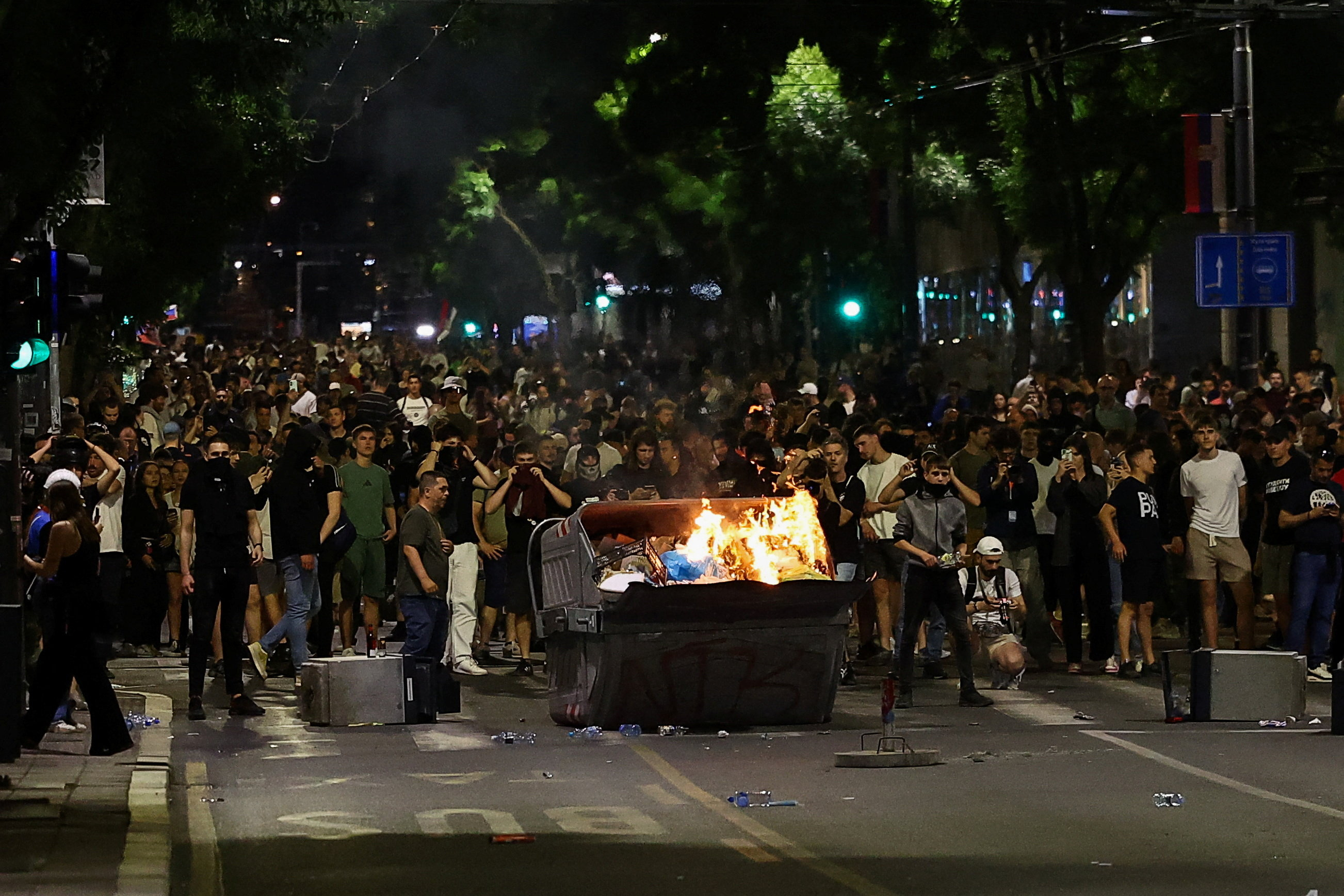 Demonstrators stand in a road by a fire, during a studen