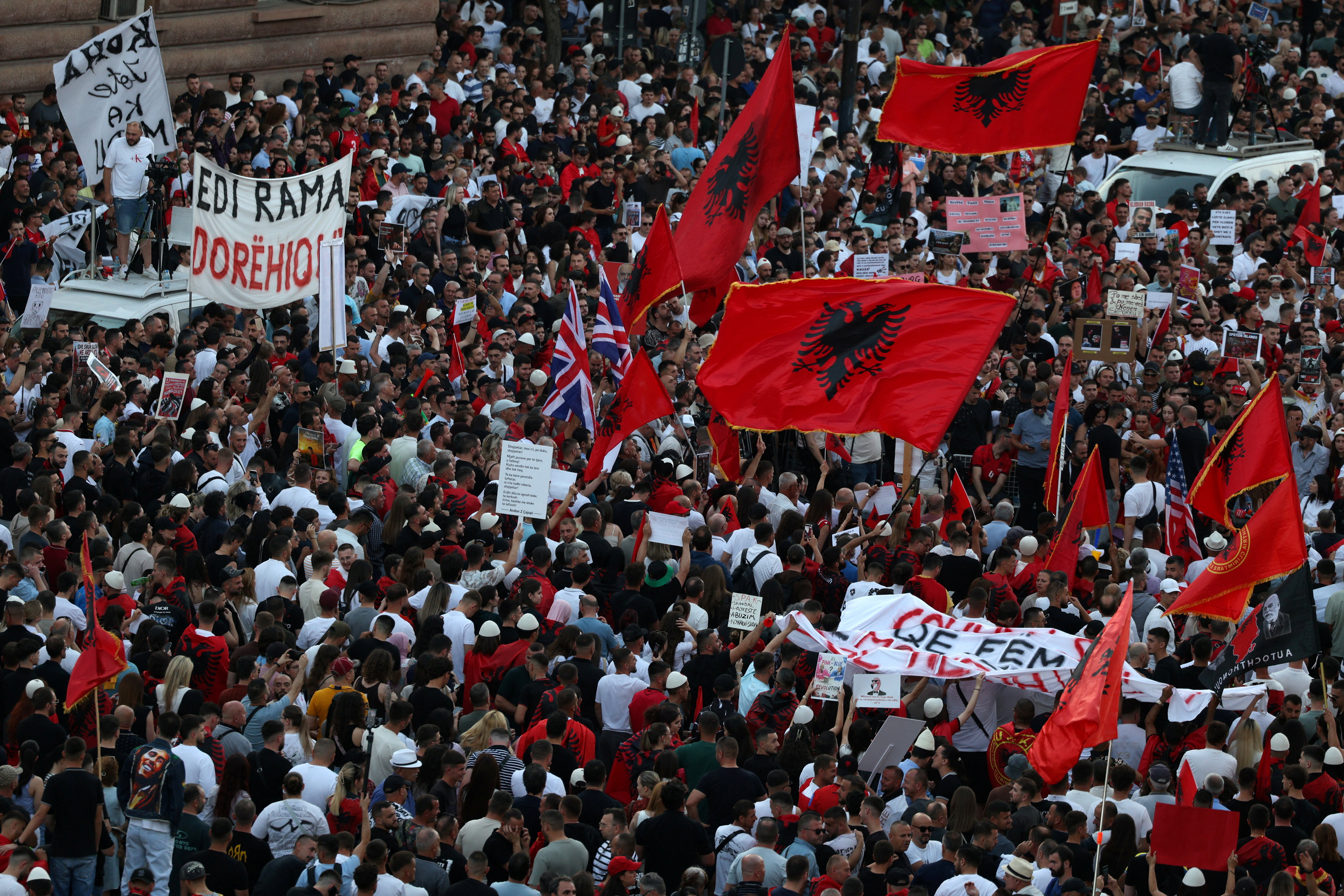 Protesters hold Albanian and British Union Jack national flags