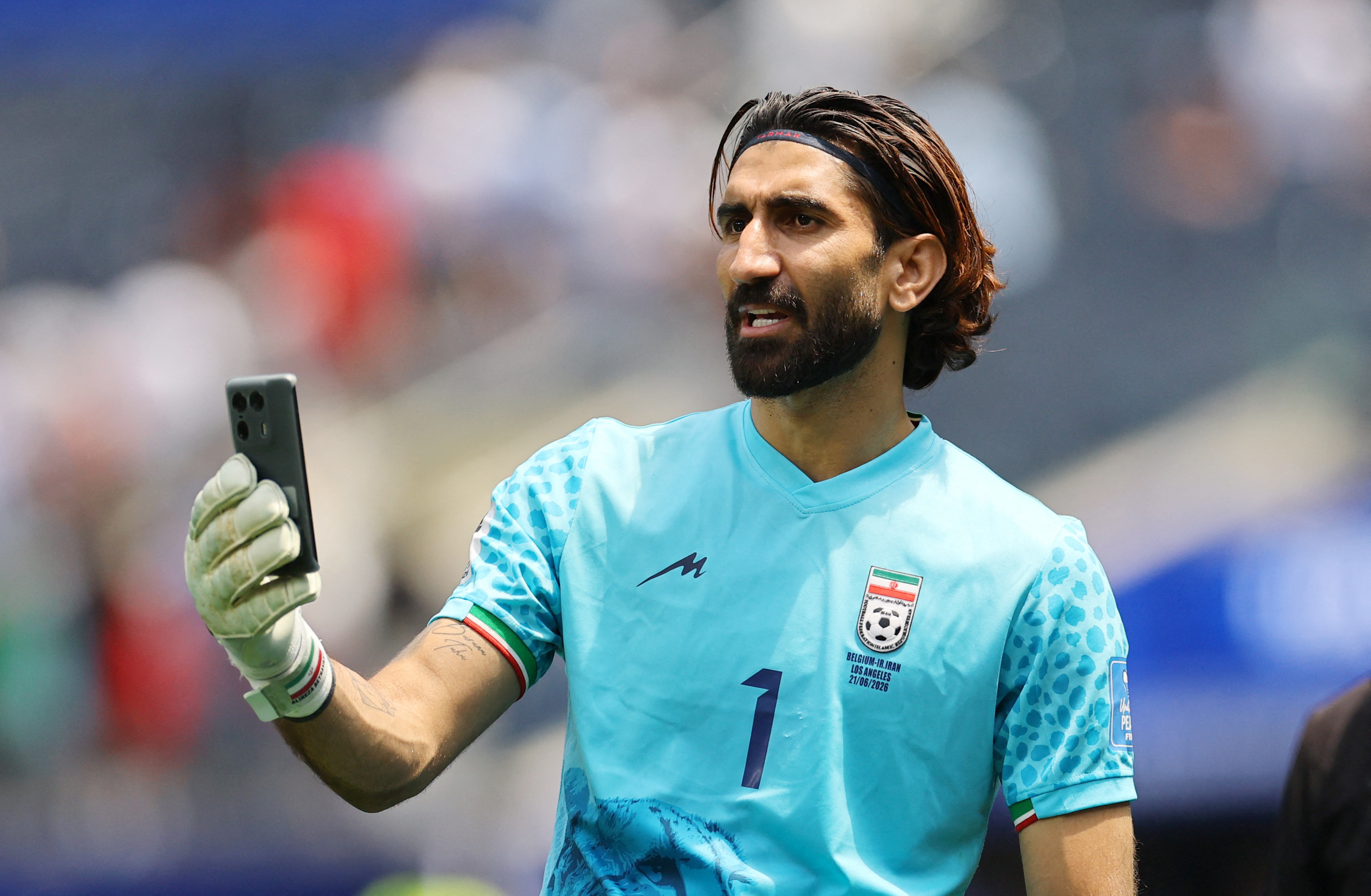 Soccer Football - FIFA World Cup 2026 - Group G - Belgium v Iran - Los Angeles Stadium, Inglewood, California, U.S. - June 21, 2026 Iran's Alireza Beiranvand makes a video call on a mobile phone after the match REUTERS/Daniel Cole