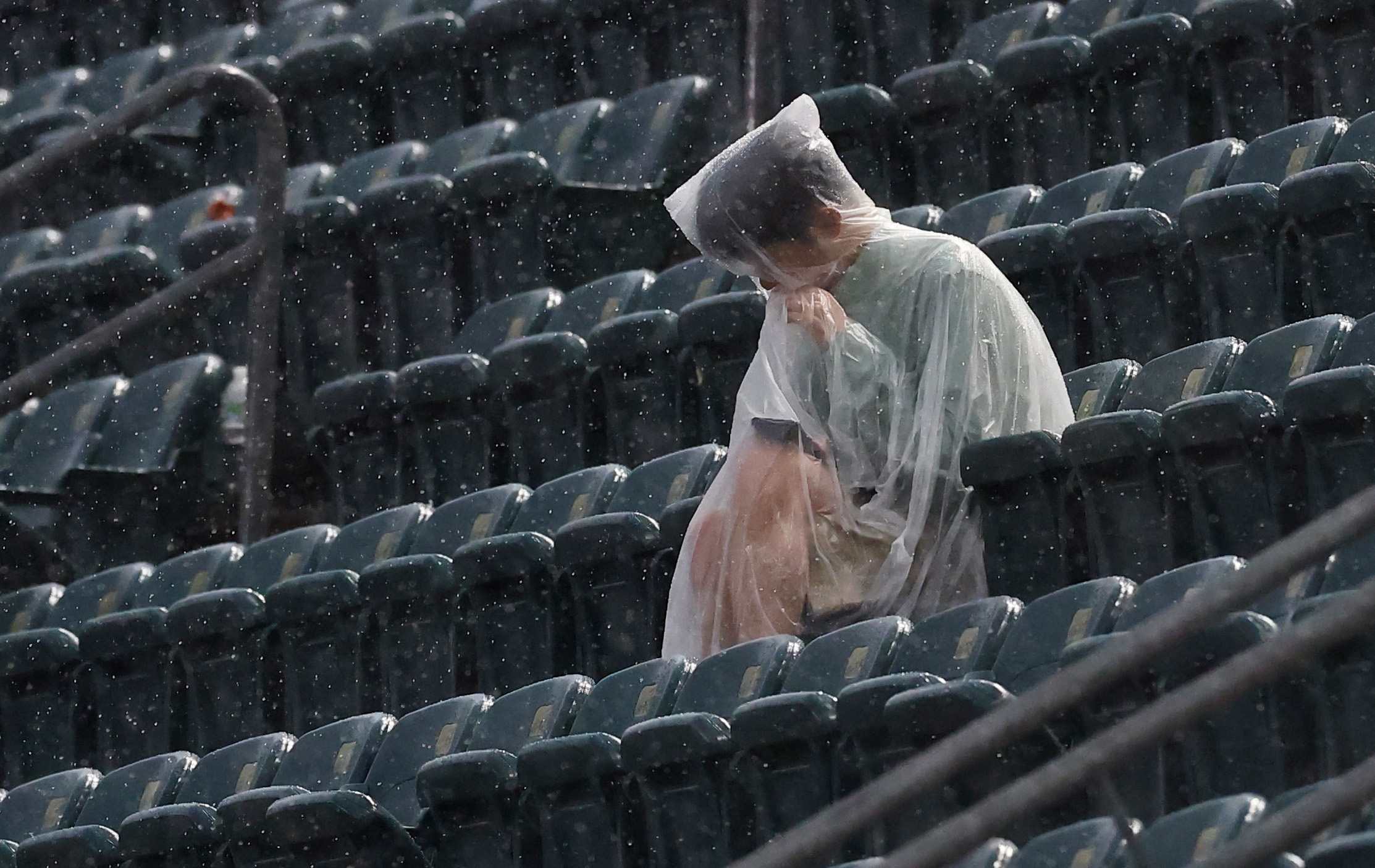 Soccer Football - FIFA World Cup 2026 - Group I - France v Iraq - Philadelphia Stadium, Philadelphia, Pennsylvania, U.S. - June 22, 2026 A fan in a poncho sits in the stands after a weather warning was displayed on the big screen as the second half is del