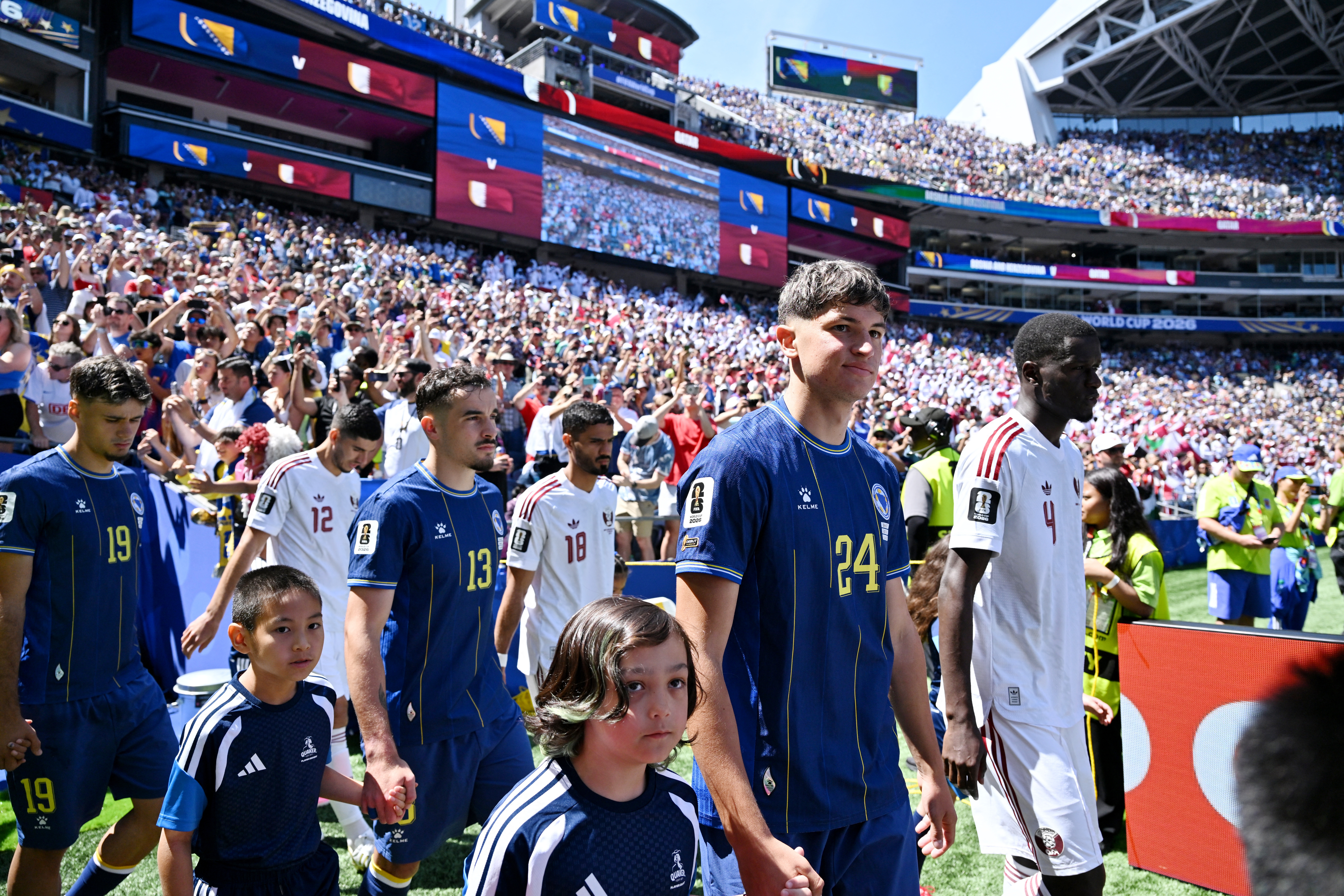 Soccer Football - FIFA World Cup 2026 - Group B - Bosnia and Herzegovina v Qatar - Seattle Stadium, Seattle, Washington, U.S. - June 24, 2026 Bosnia and Herzegovina's Arjan Malic and Qatar's Issa Laye walk onto the pitch before the match IMAGN IMAGES via
