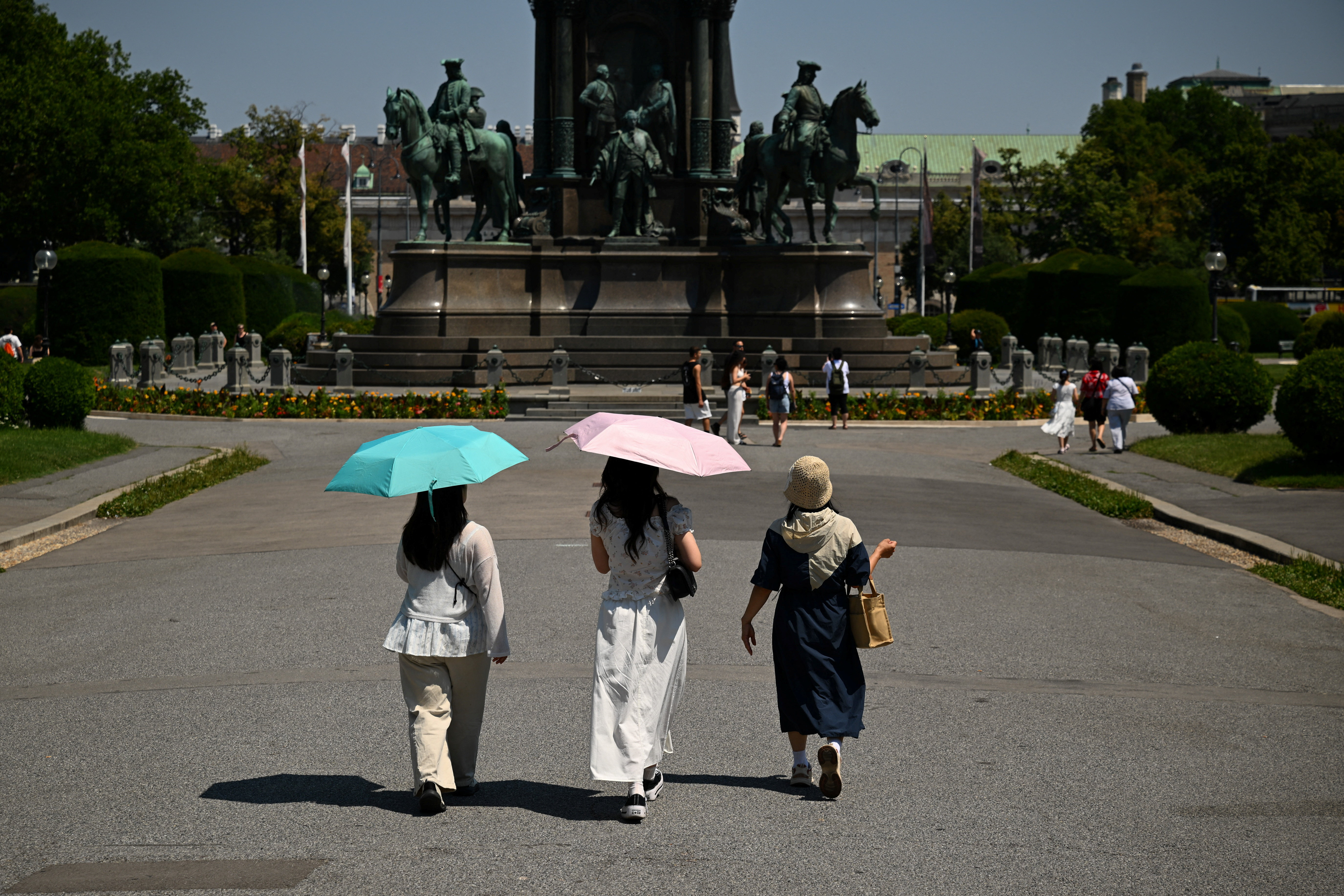 People carrying umbrellas walk in the city center during