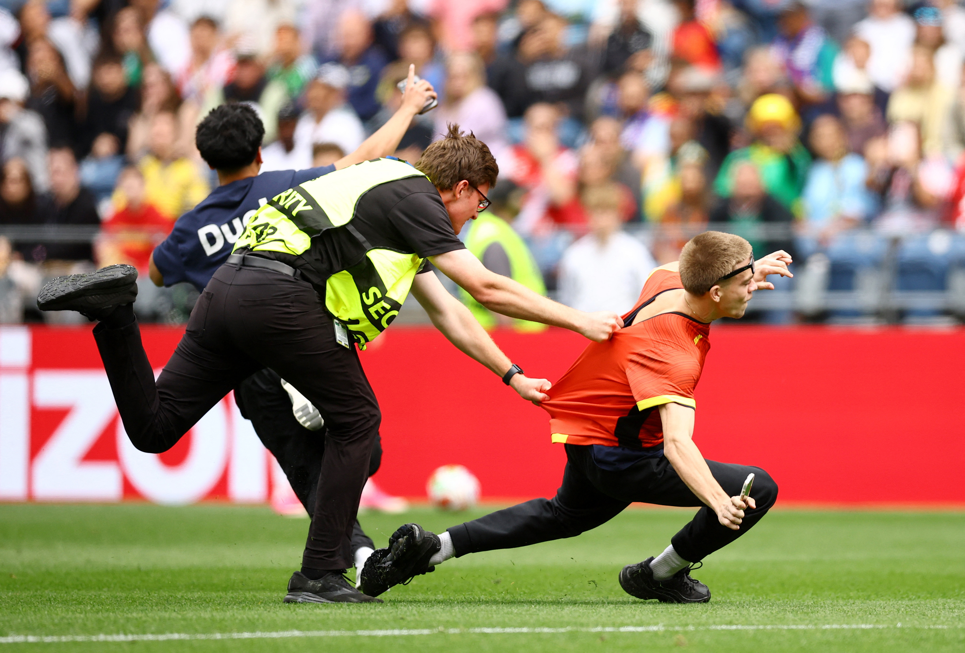 Soccer Football - FIFA World Cup 2026 - Round of 32 - Belgium v Senegal - Seattle Stadium, Seattle, Washington, U.S. - July 1, 2026 Security staff attempt to apprehend a pitch invader REUTERS/Albert Gea