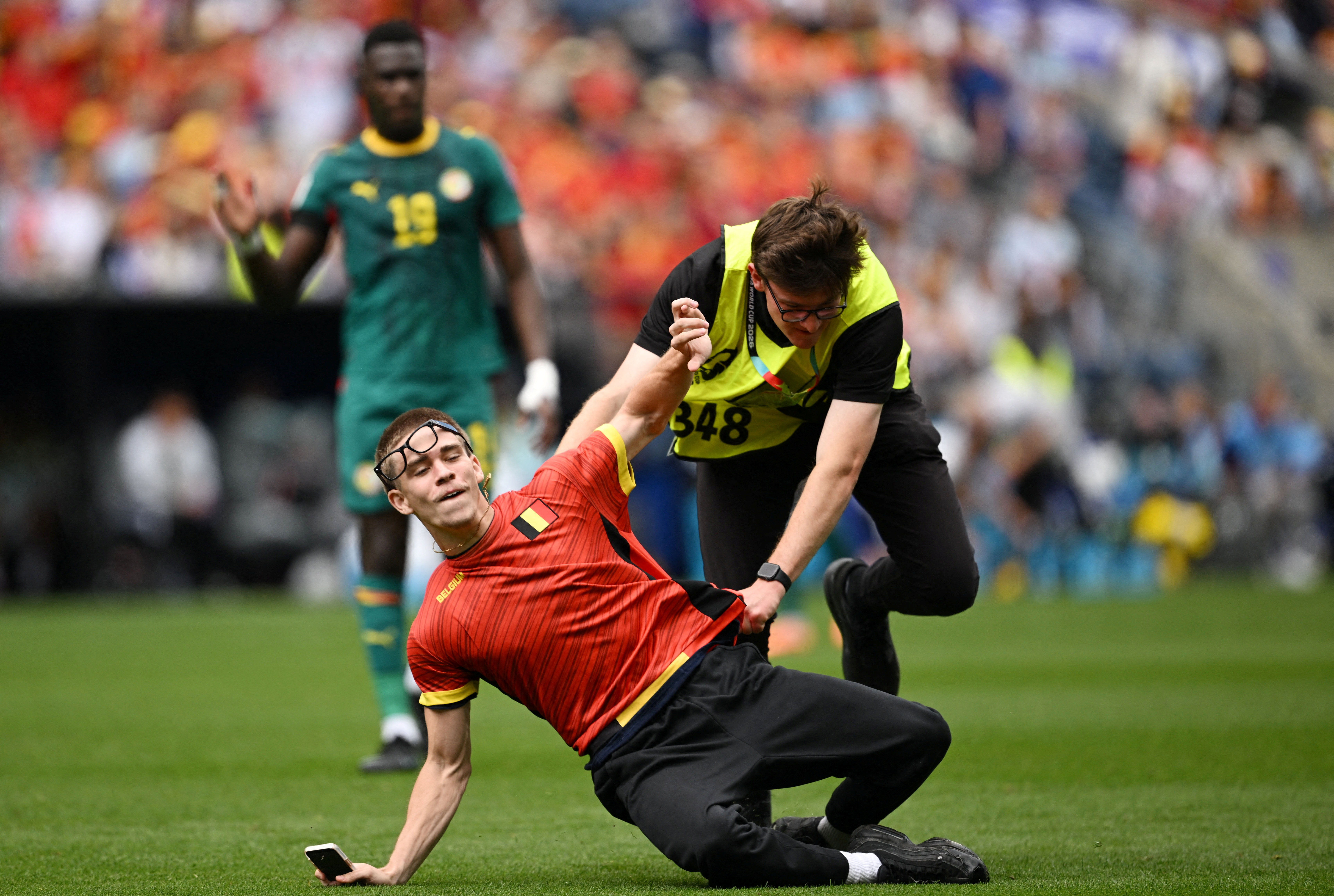 Soccer Football - FIFA World Cup 2026 - Round of 32 - Belgium v Senegal - Seattle Stadium, Seattle, Washington, U.S. - July 1, 2026 A pitch invader is detained by a steward IMAGN IMAGES via Reuters/Troy Wayrynen     TPX IMAGES OF THE DAY