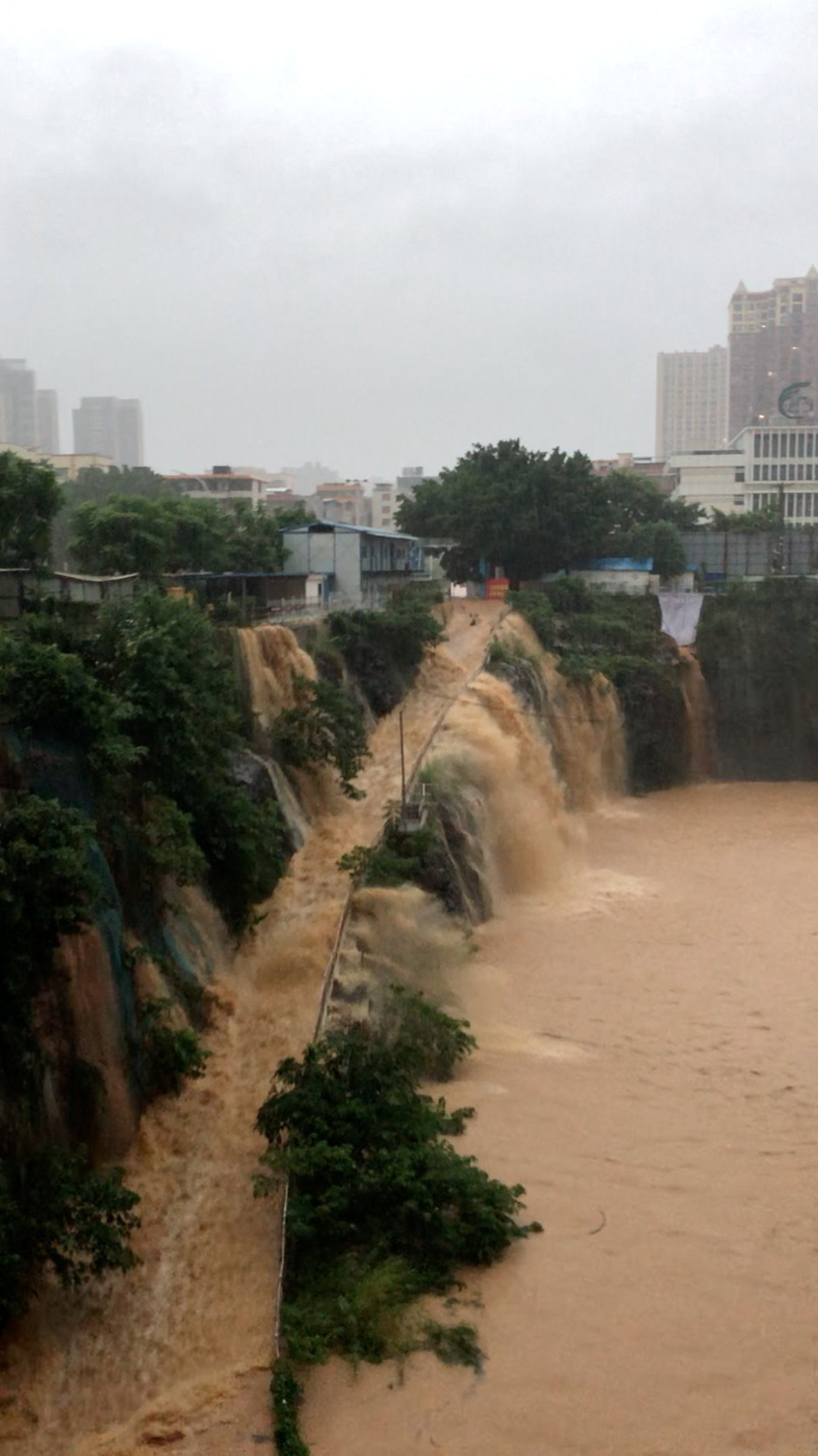 Floodwater flows down the side of a ramp at a construction site