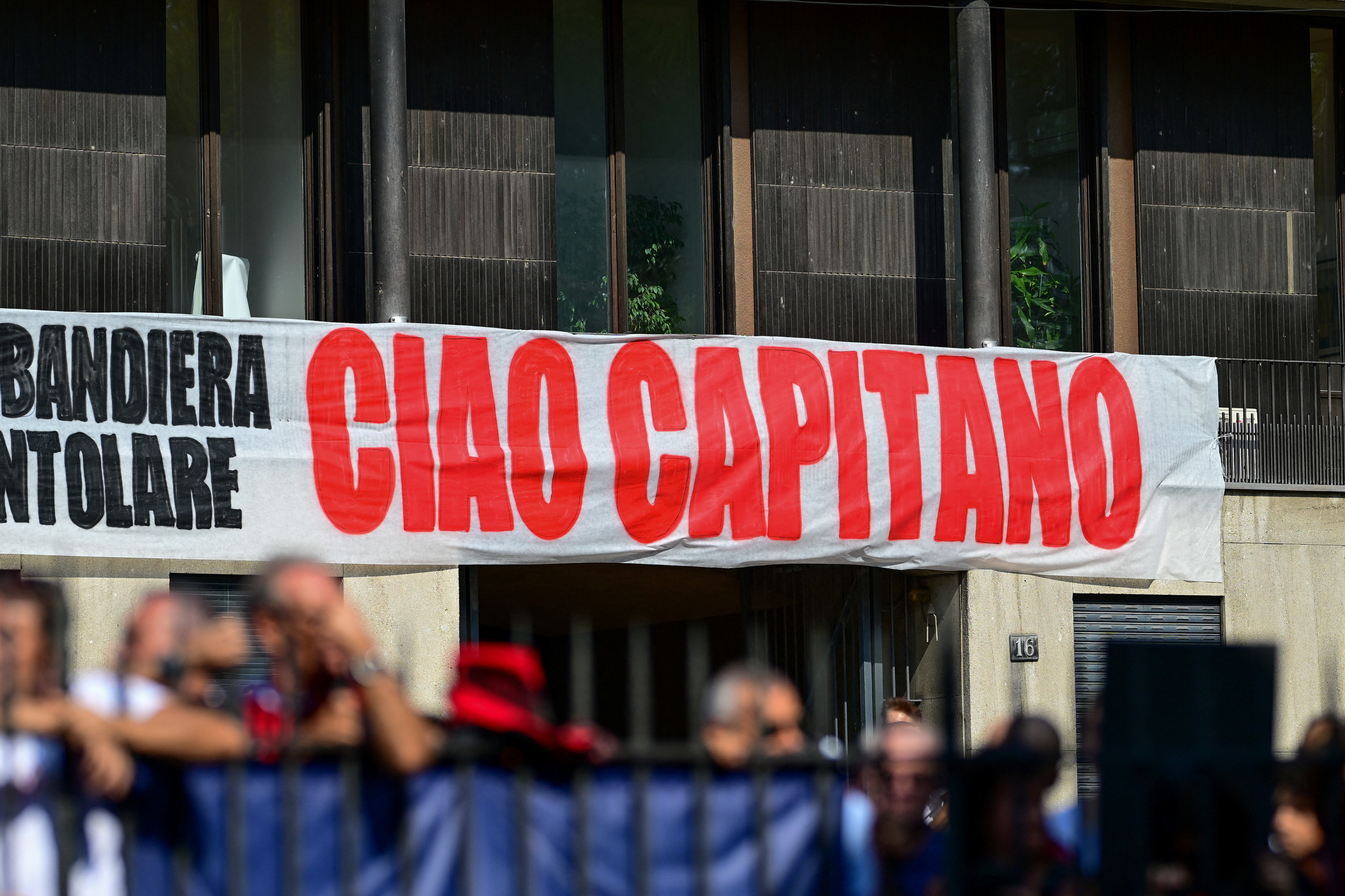 Mourners gather outside the Basilica of Sant'Ambrogio on the day of the funeral of former AC Milan and Italy soccer player Franco Baresi in Milan, Italy, August 4, 2026. Banner reads: "Goodbye, Captain". REUTERS/Daniele Mascolo