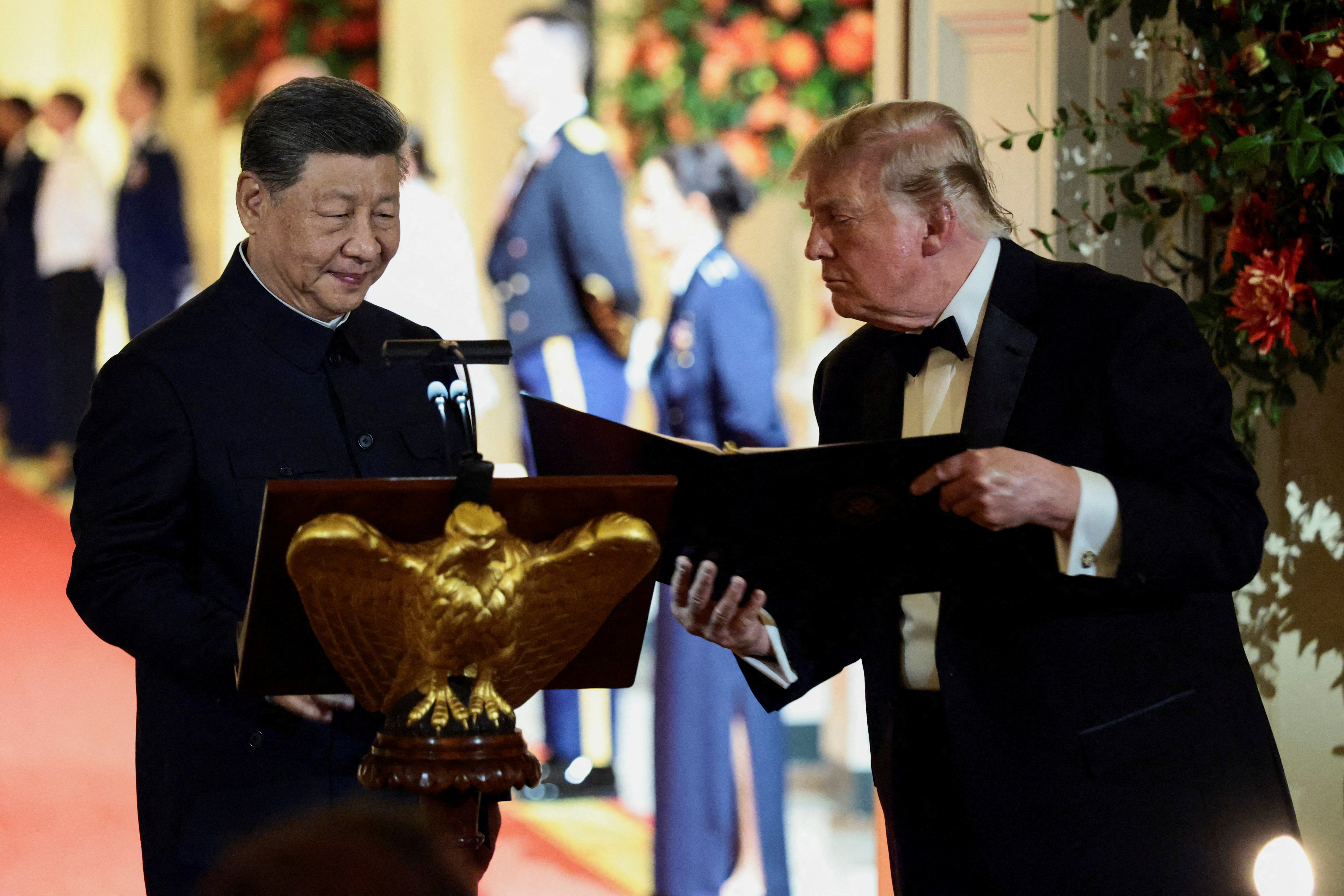 US President Donald Trump holds a binder as he stands next to Chinese President Xi Jinping before Xi delivers a speech during a state dinner at the White House in Washington, D.C., US, September 24, 2026. REUTERS/Evelyn Hockstein     TPX IMAGES OF THE DAY