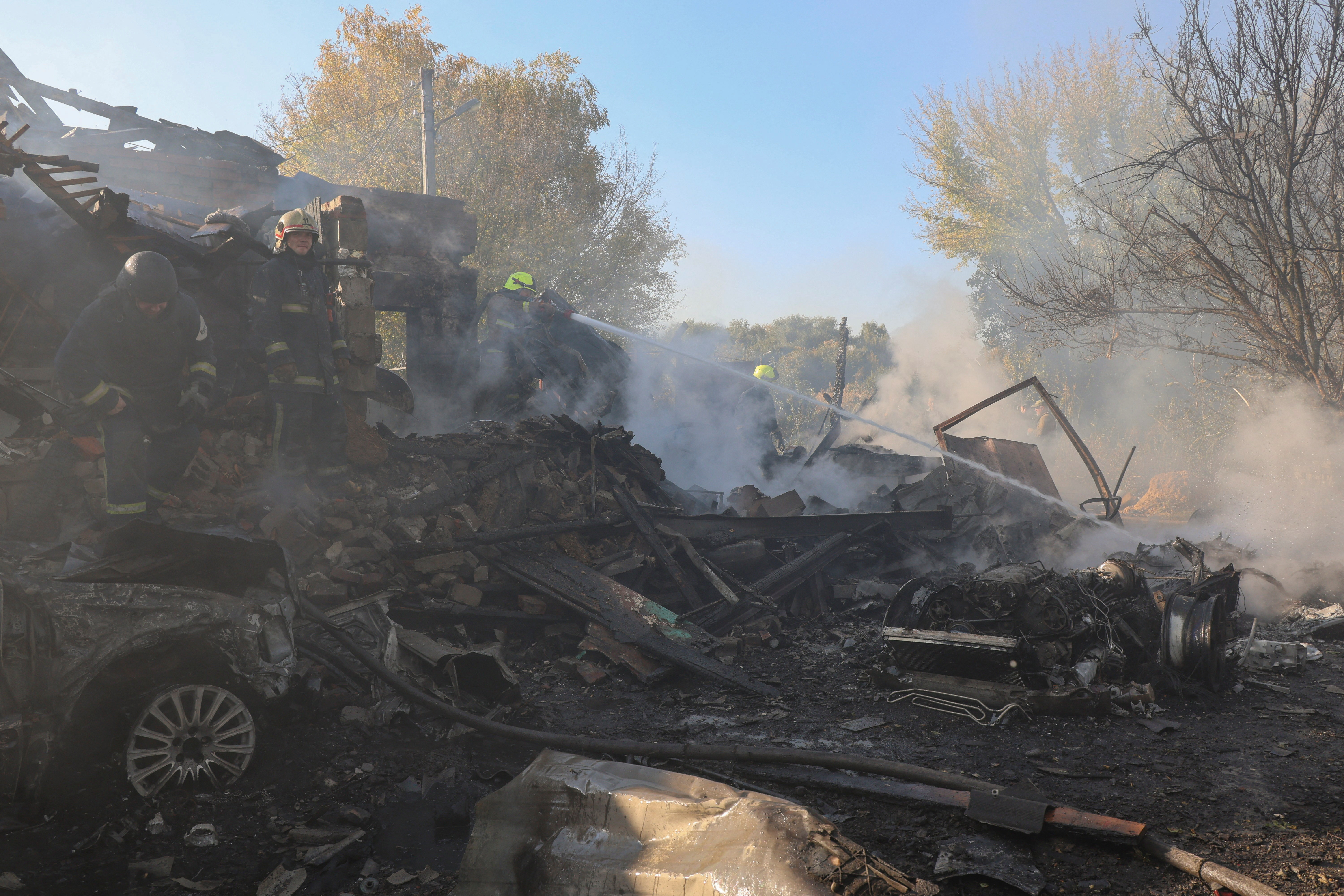 Firefighters work at the site of private houses hit by a Russian air strike