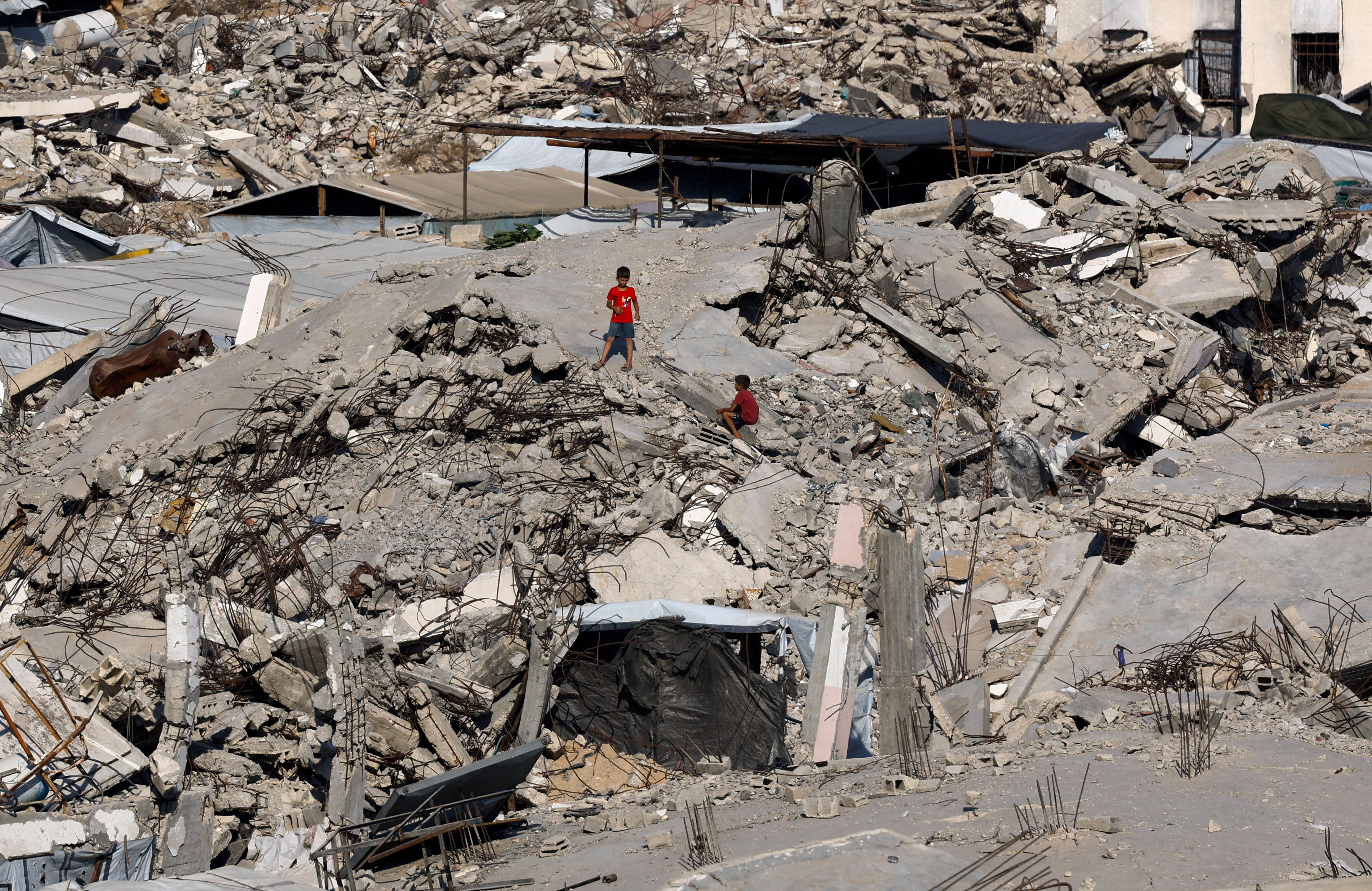 FILE PHOTO: Young Palestinians amid the rubble of buildings destroyed during the war, at Jabalia refugee camp in the northern Gaza Strip