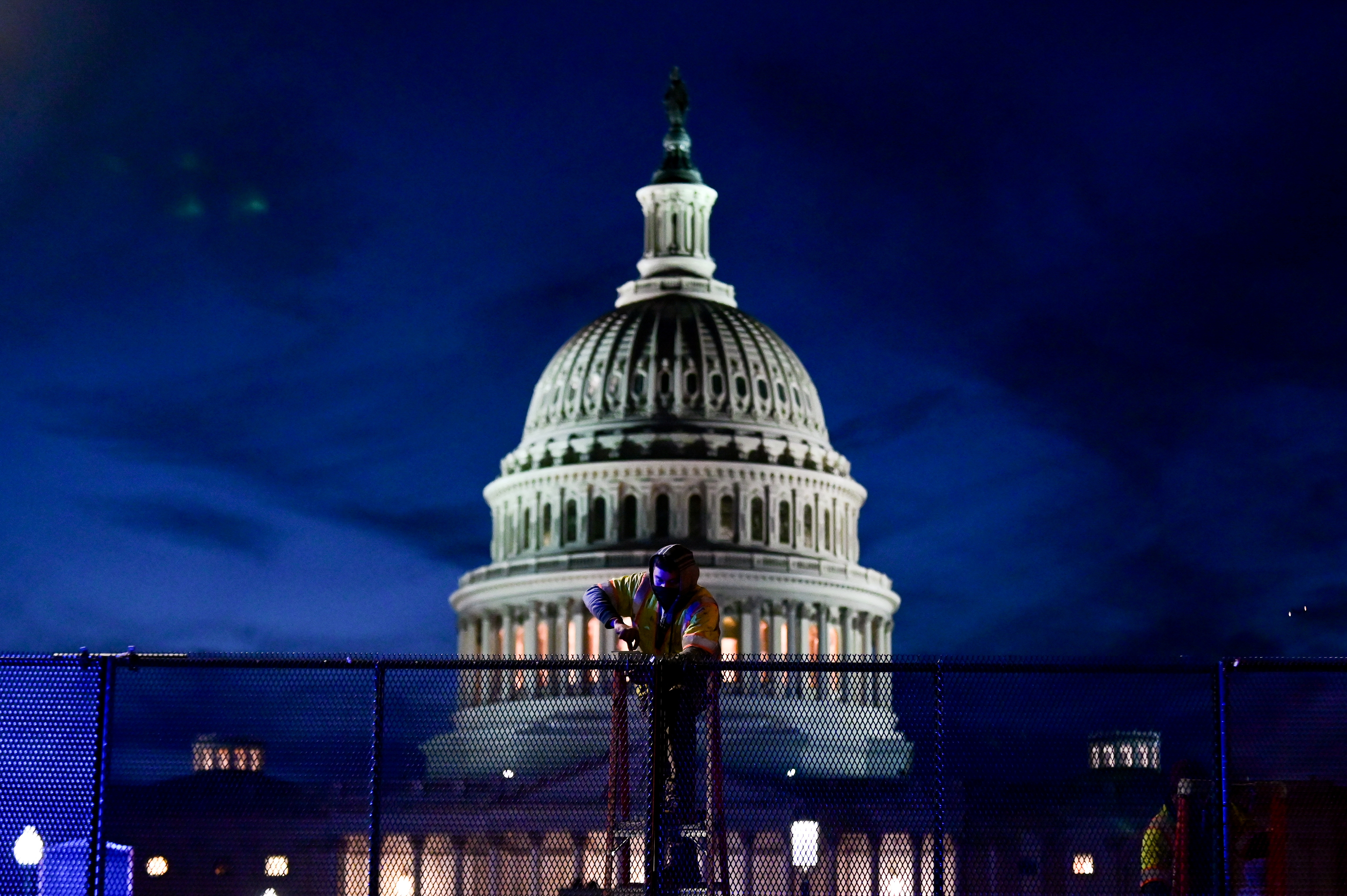 Workers install heavy-duty security fencing around the U.S. Capitol a day after supporters of U.S. President Donald Trump stormed the Capito