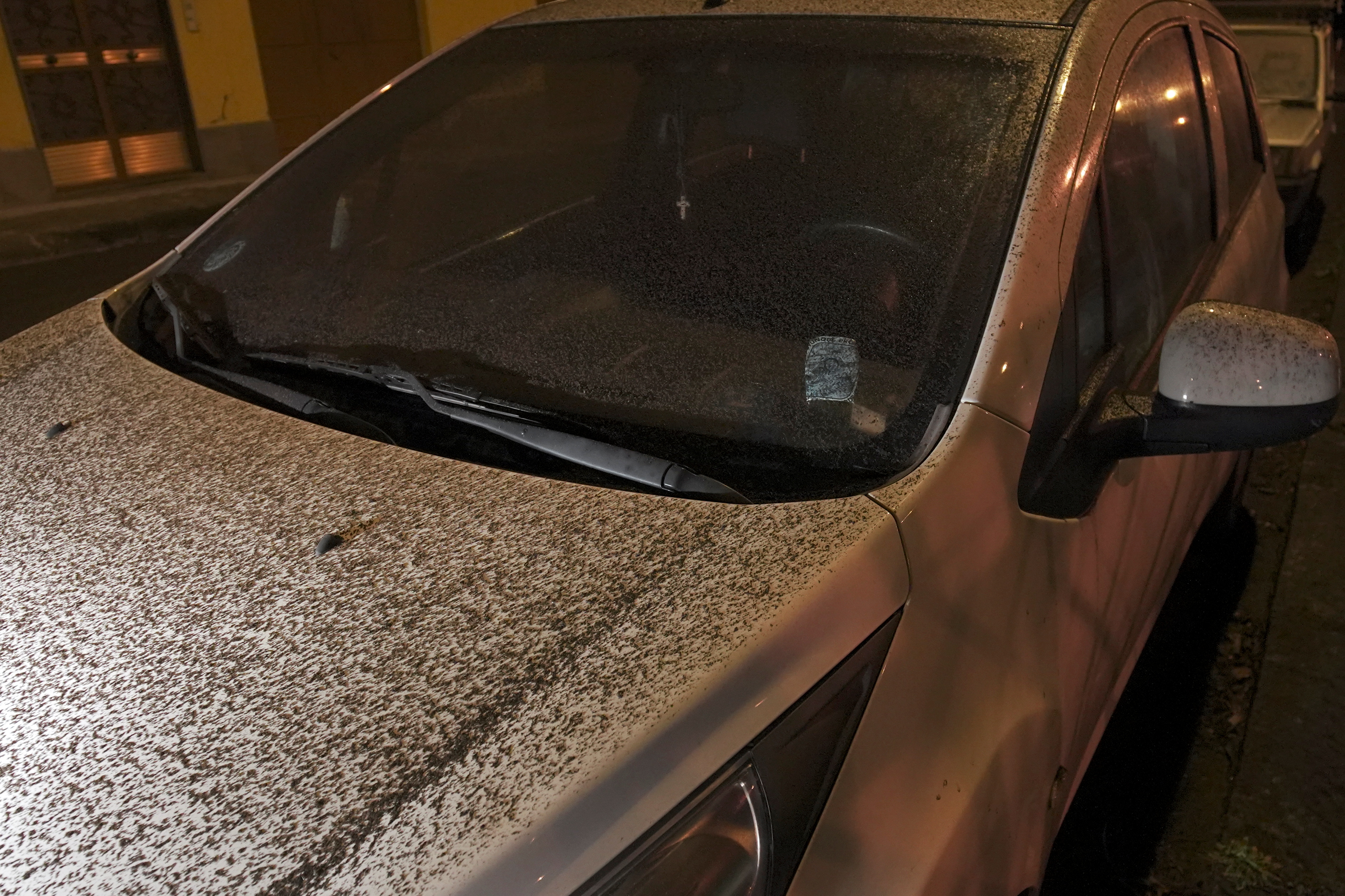 A car is covered with volcanic ash during an eruption of Mount Etna in Fleri