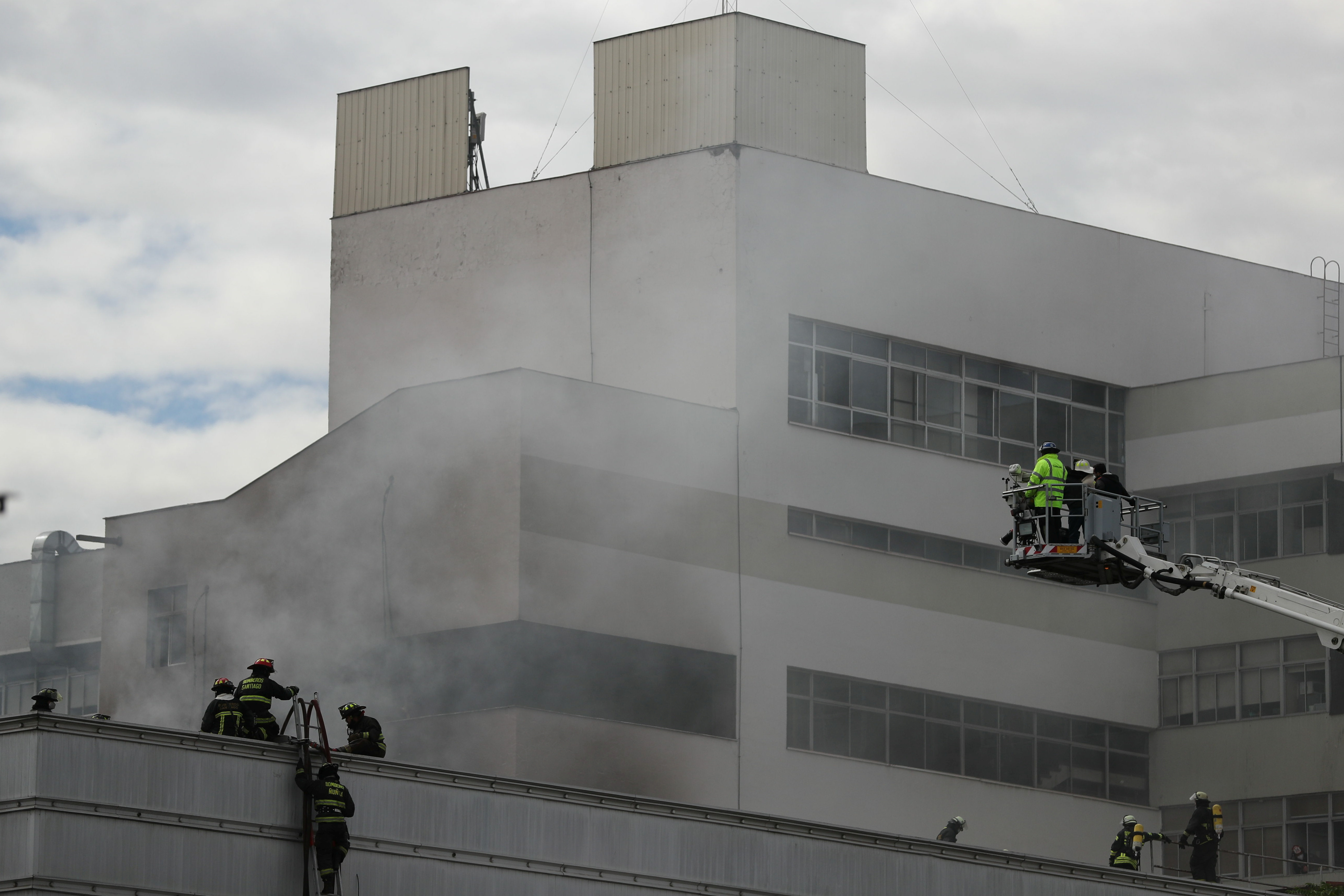 Firefighters work to put out a fire in a hospital in Santiago