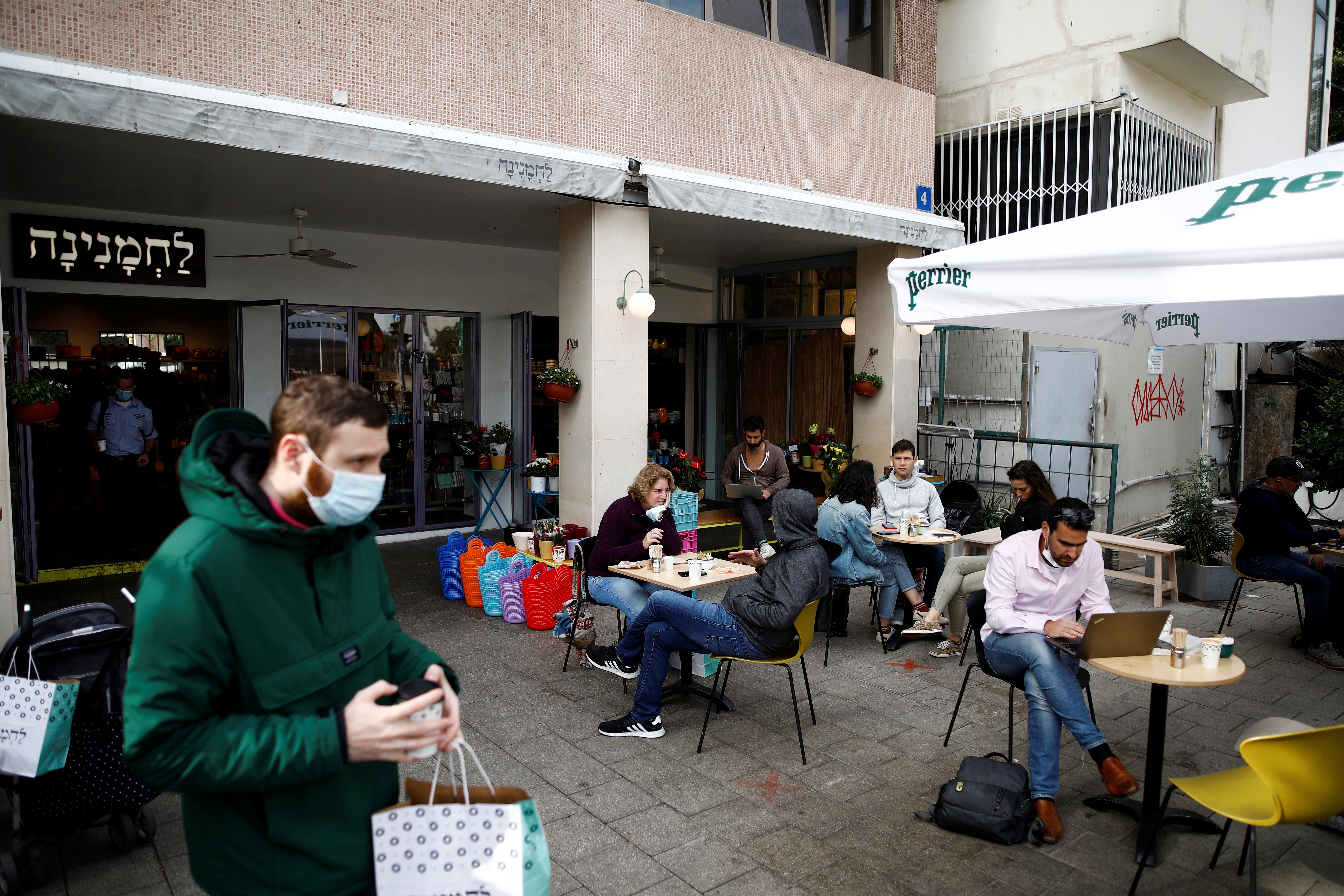Guests sit and take away food and drinks from a cafe in Tel Aviv