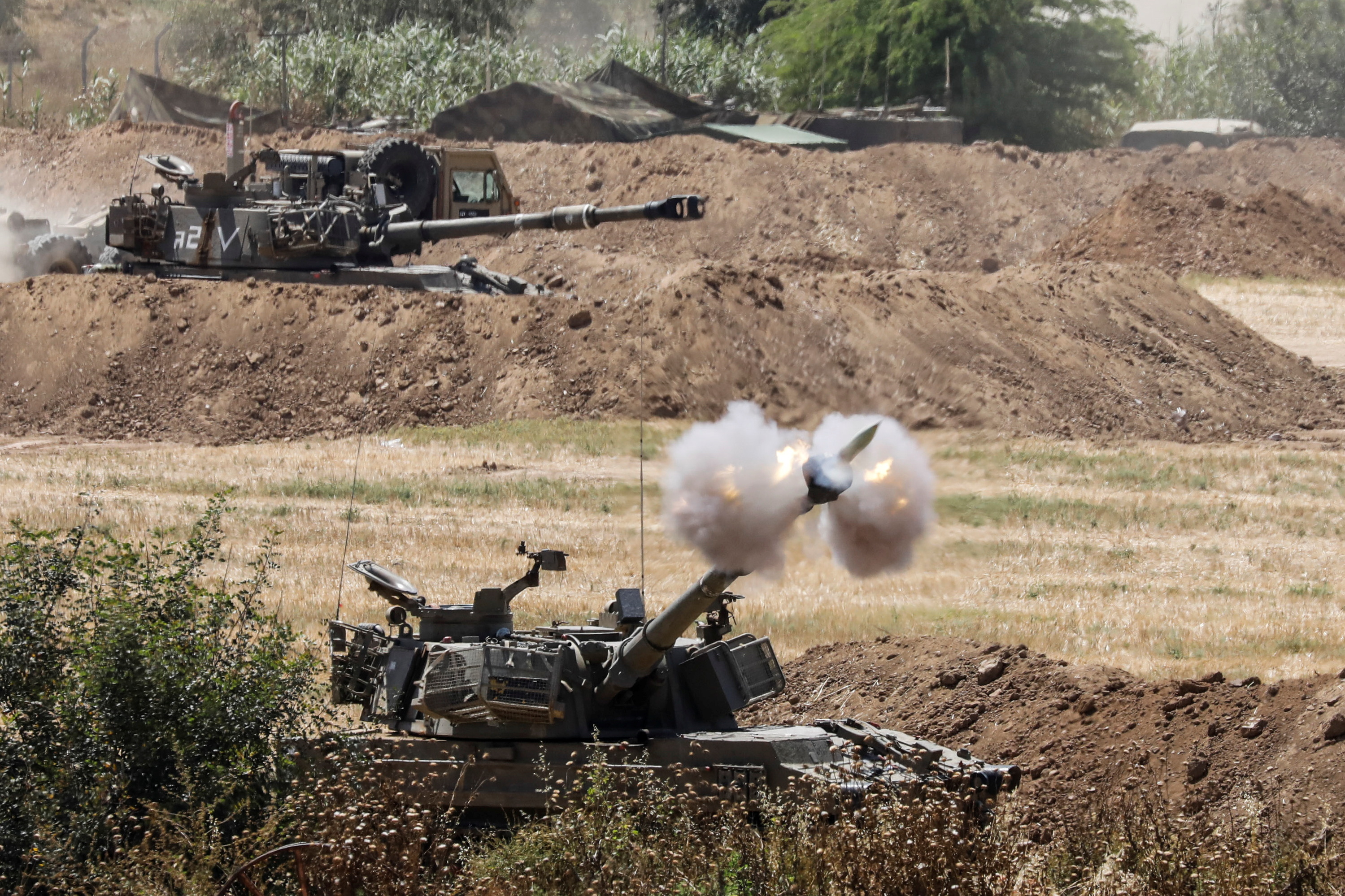 An Israeli military artillery unit fires a shell, as seen from the Israeli side of the border with the Gaza Strip