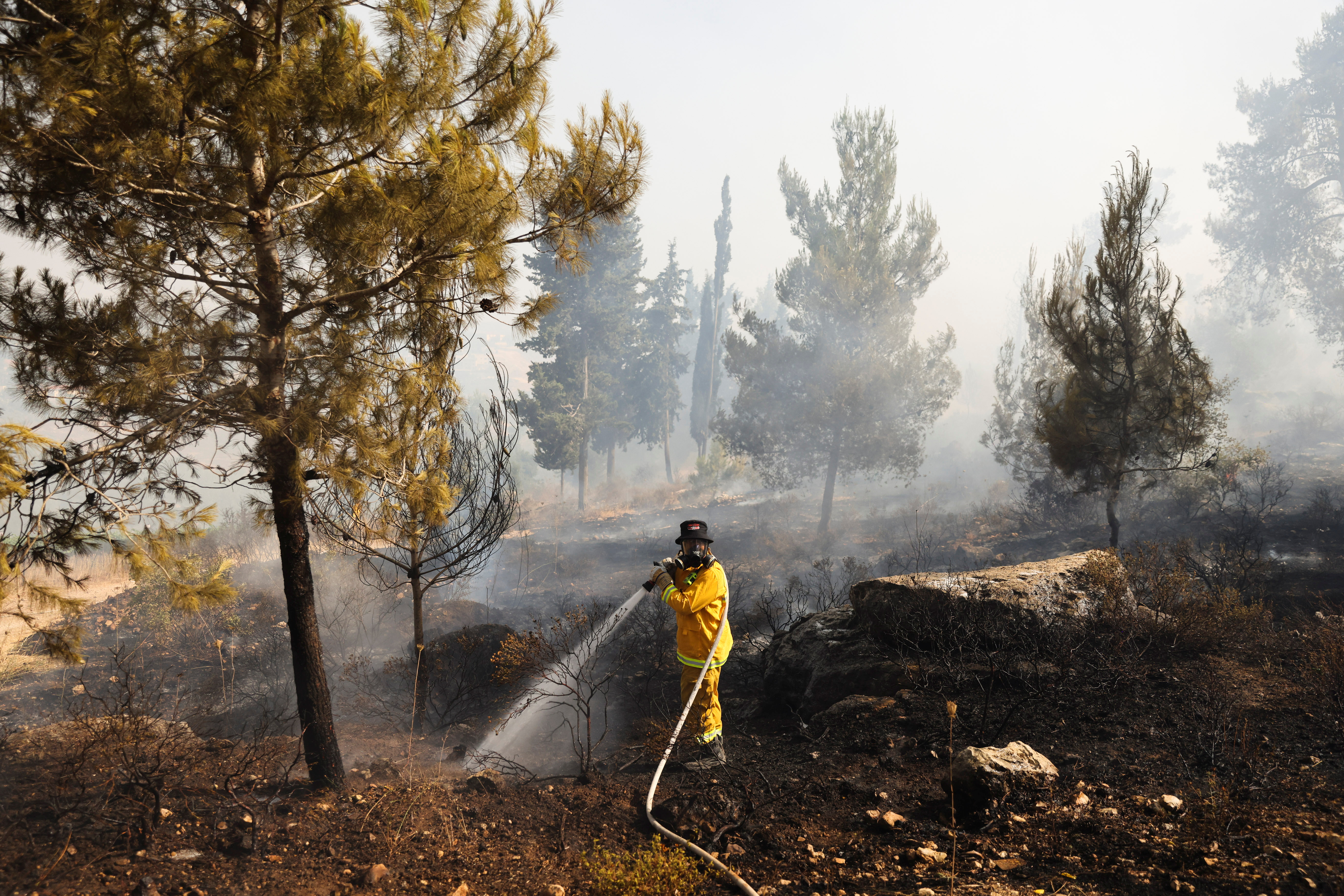A fire-fighter extinguishes a fire near Kibbutz Maale Hahamisha in Israel, in the outskirts of Jerusalem