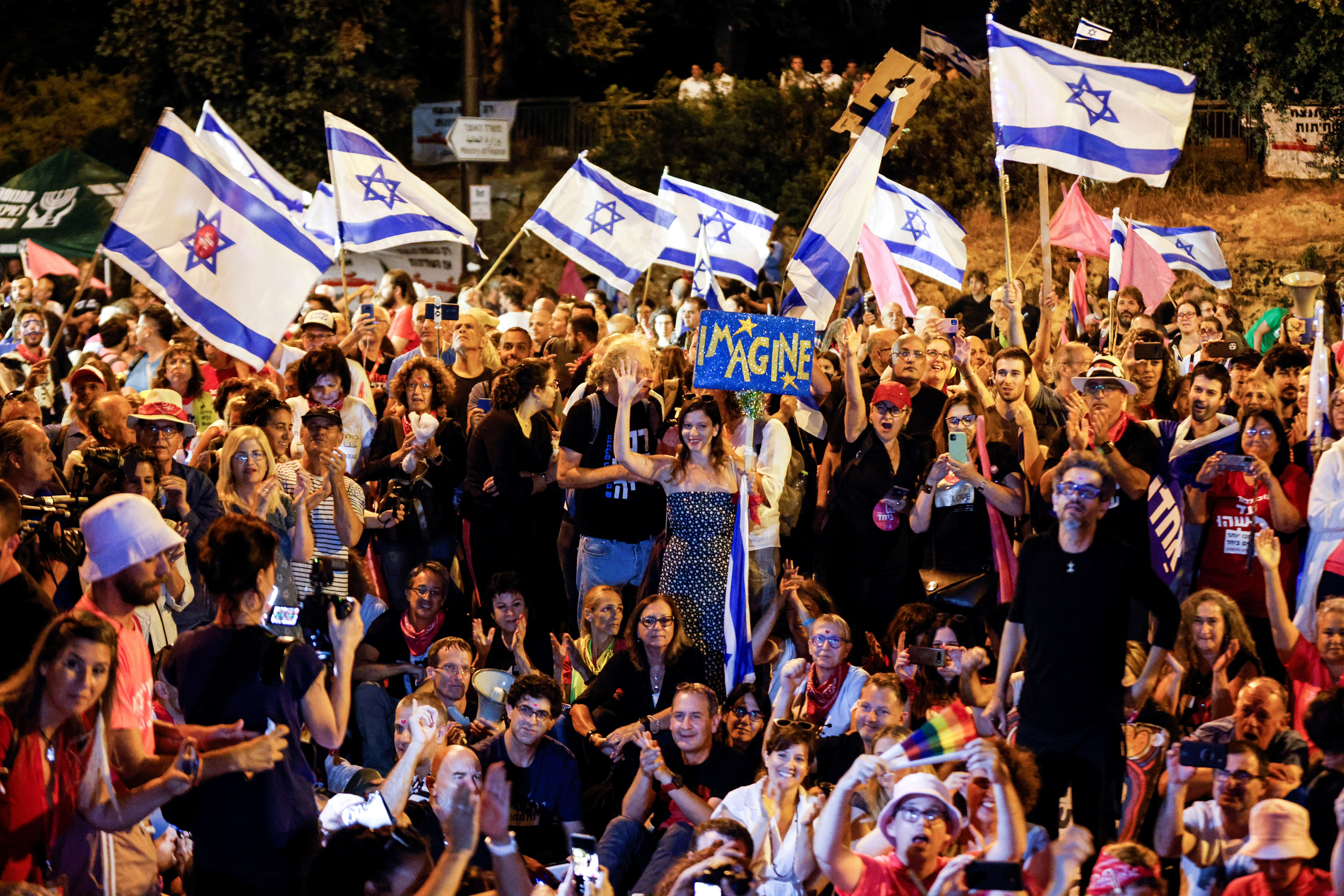 Supporters of the proposed new coalition government watch the voting session at the Knesset, Israel's parliament, to approve and swear-in the new government, in Jerusalem