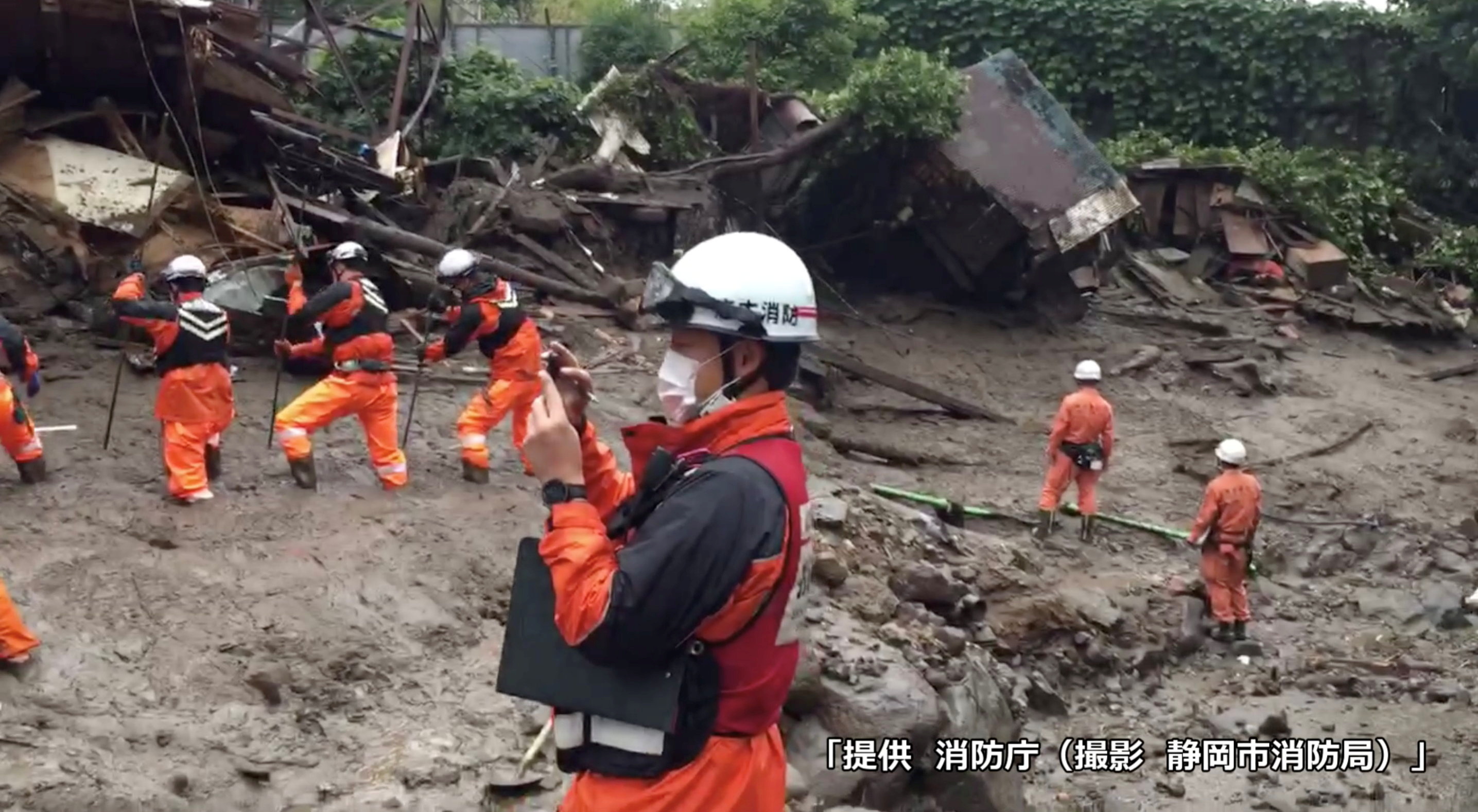 Handout video grab image shows firefighters conduct search and rescue operation at a mudslide site caused by heavy rain in Atami, Japan