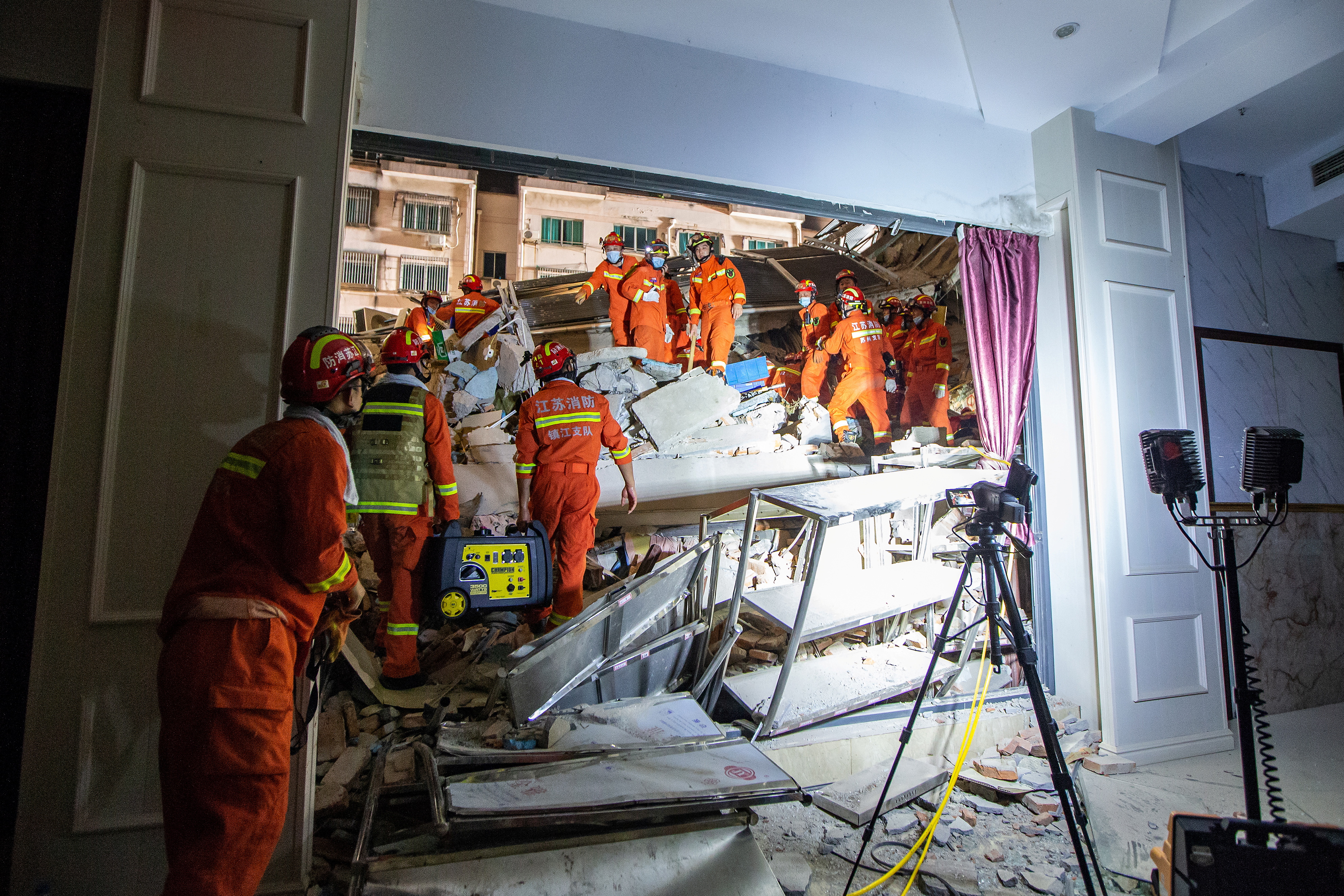 Rescue workers work at the site where a hotel building collapsed in Suzhou, Jiangsu