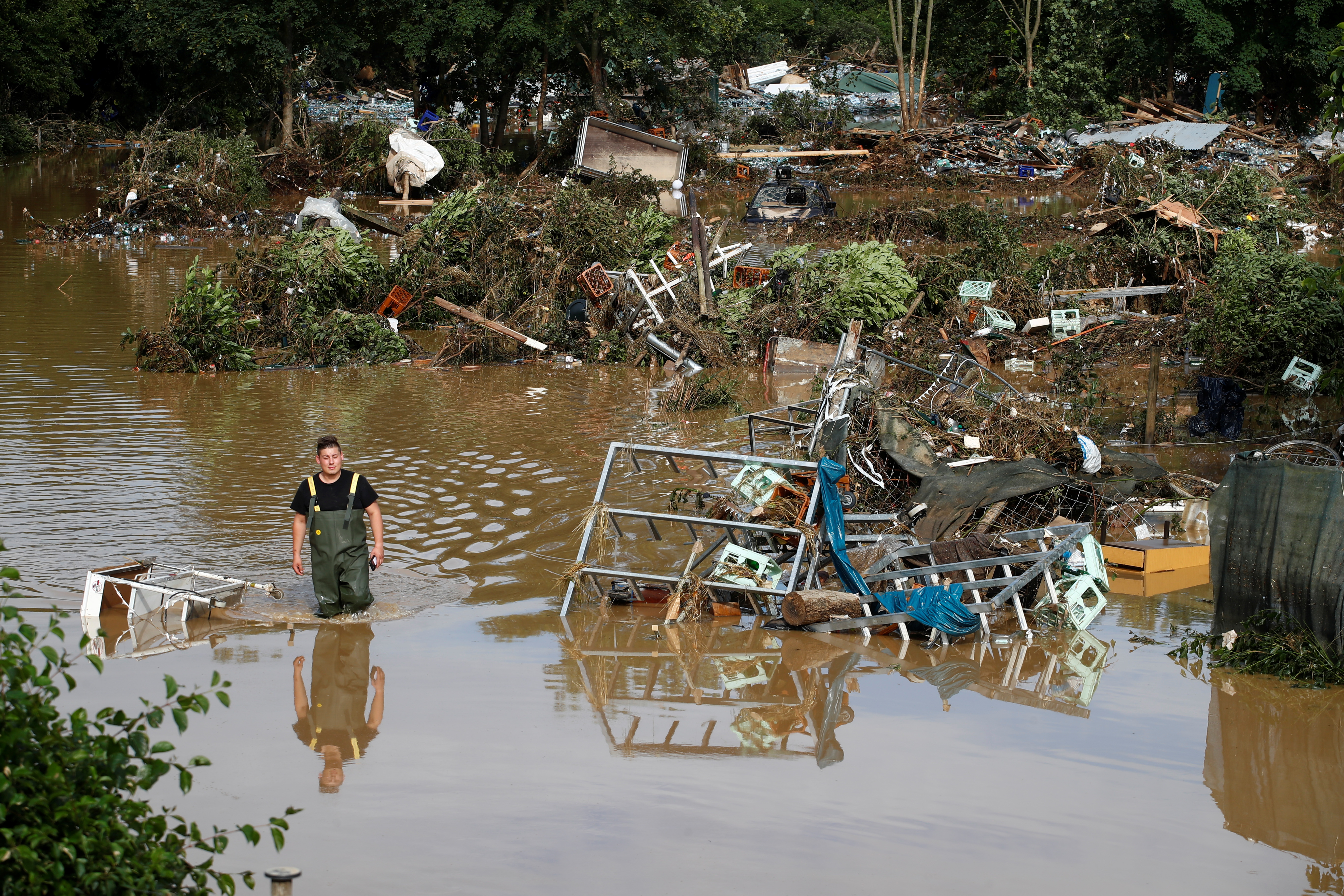 A man walks through the water in an area affected by floods following heavy rainfalls in Bad Neuenahr-Ahrweiler