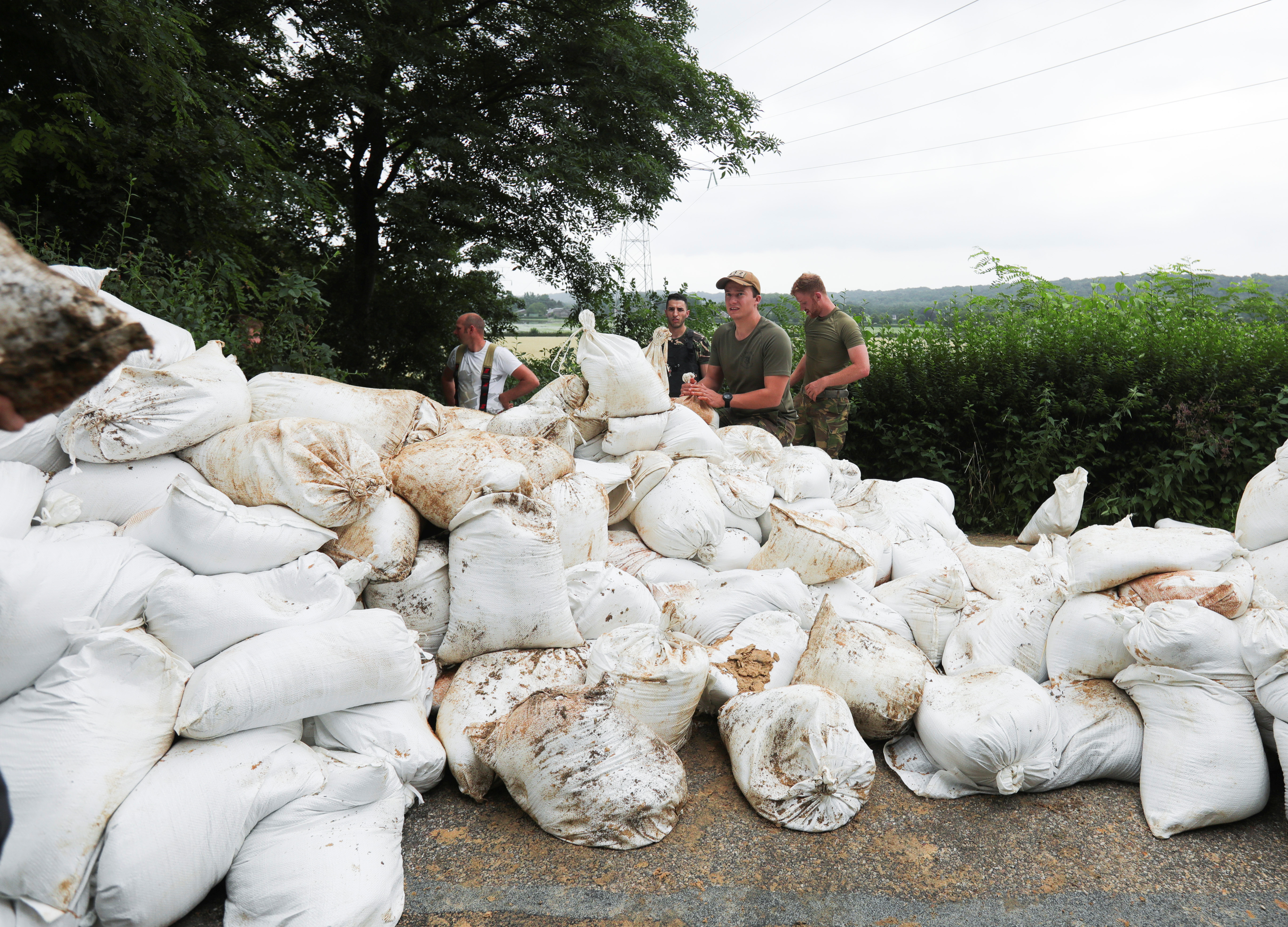 Men work to repair a sandbag dike against a flood in Guelle