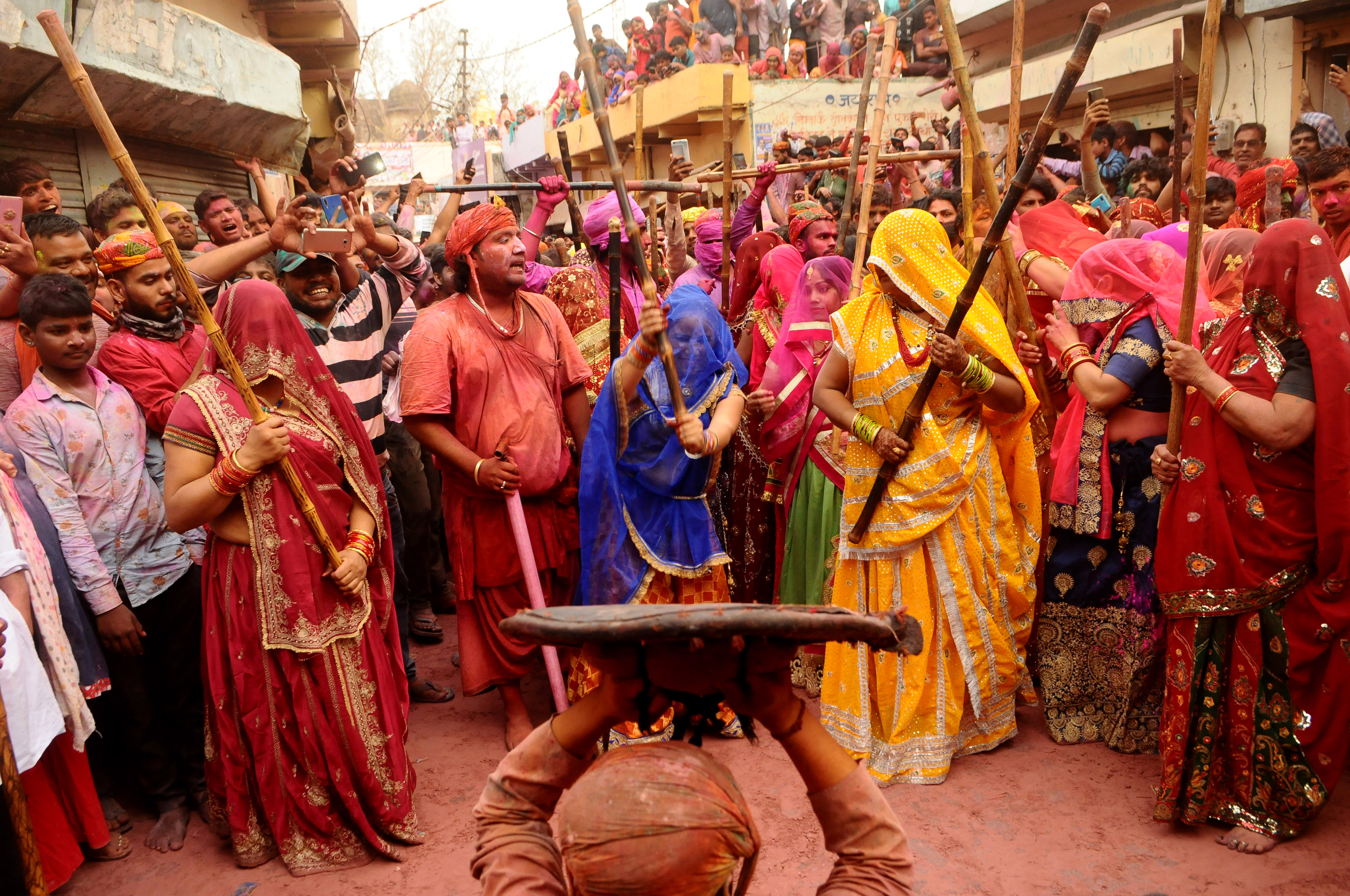 BARSANA, INDIA -MARCH 23, 2021 : Indian women beat men with sticks (lathi) during the Lathmar Holi celebration in the village of Barsana on the outskirts of Mathura in the northern Indian state of Uttar Pradesh, March on India 23,2021 : Imtiyaz Khan  