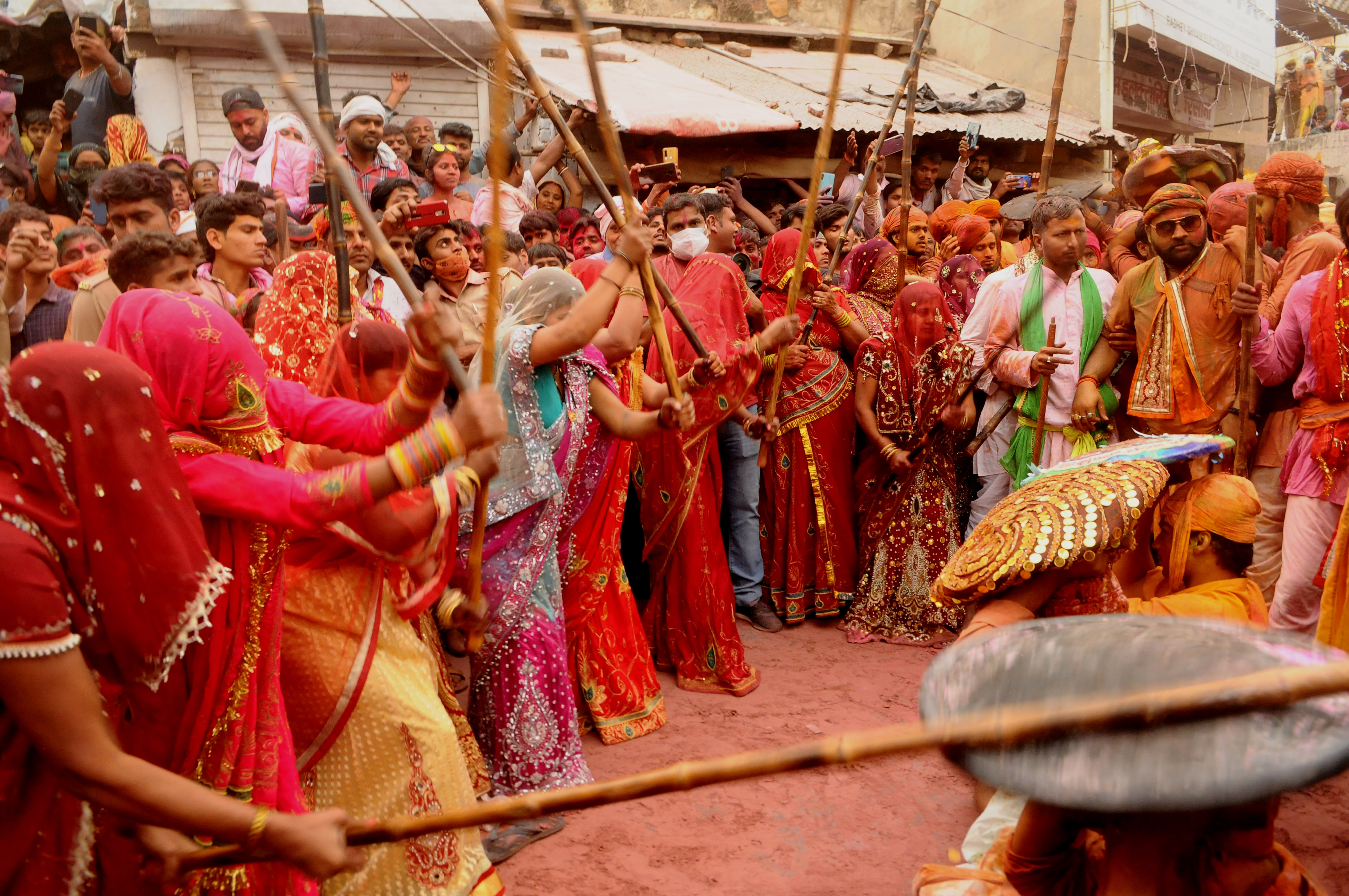 BARSANA, INDIA -MARCH 23, 2021 : Indian women beat men with sticks (lathi) during the Lathmar Holi celebration in the village of Barsana on the outskirts of Mathura in the northern Indian state of Uttar Pradesh, March on India 23,2021 : Imtiyaz Khan  