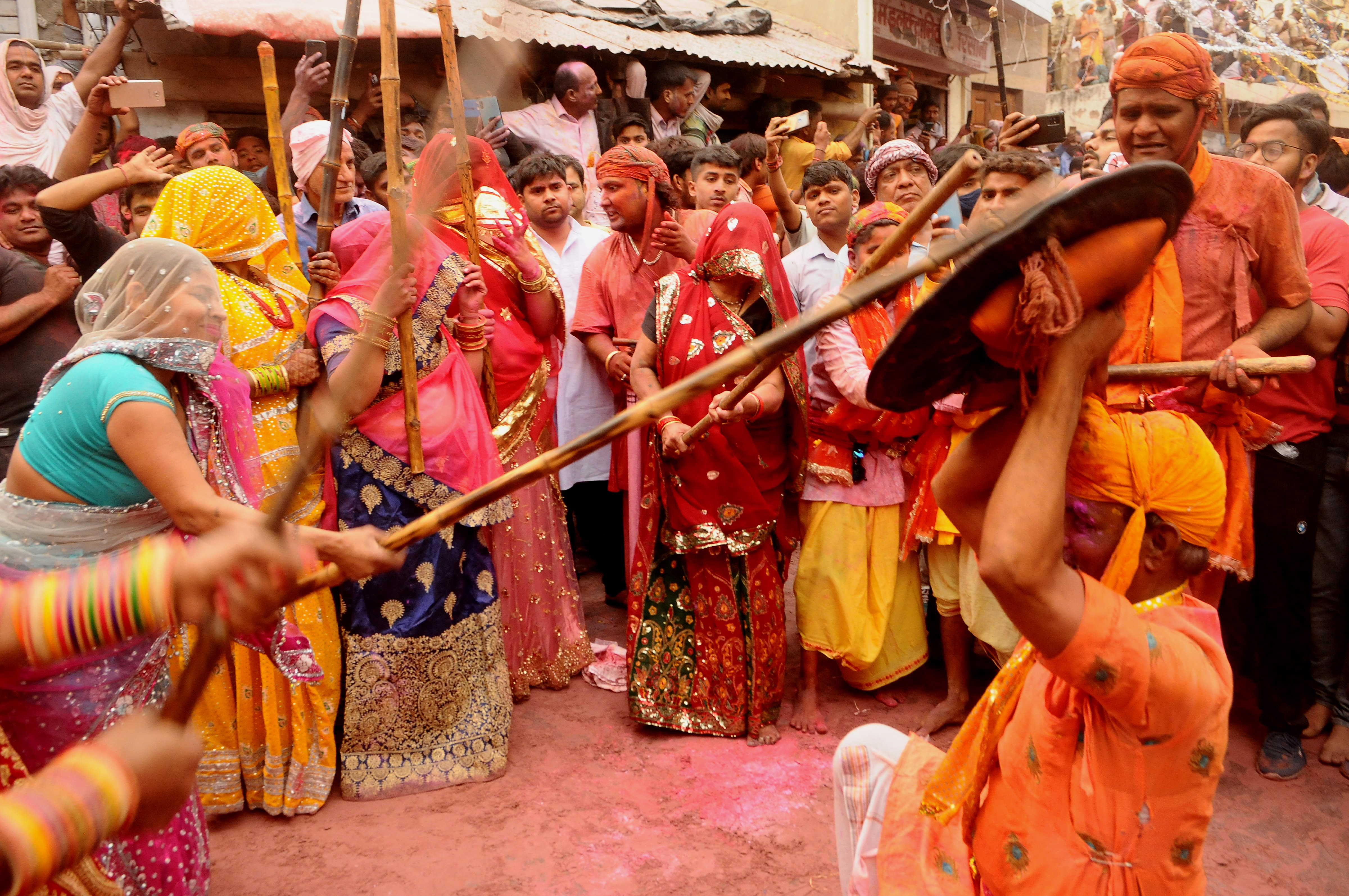 BARSANA, INDIA -MARCH 23, 2021 : Indian women beat men with sticks (lathi) during the Lathmar Holi celebration in the village of Barsana on the outskirts of Mathura in the northern Indian state of Uttar Pradesh, March on India 23,2021 : Imtiyaz Khan  