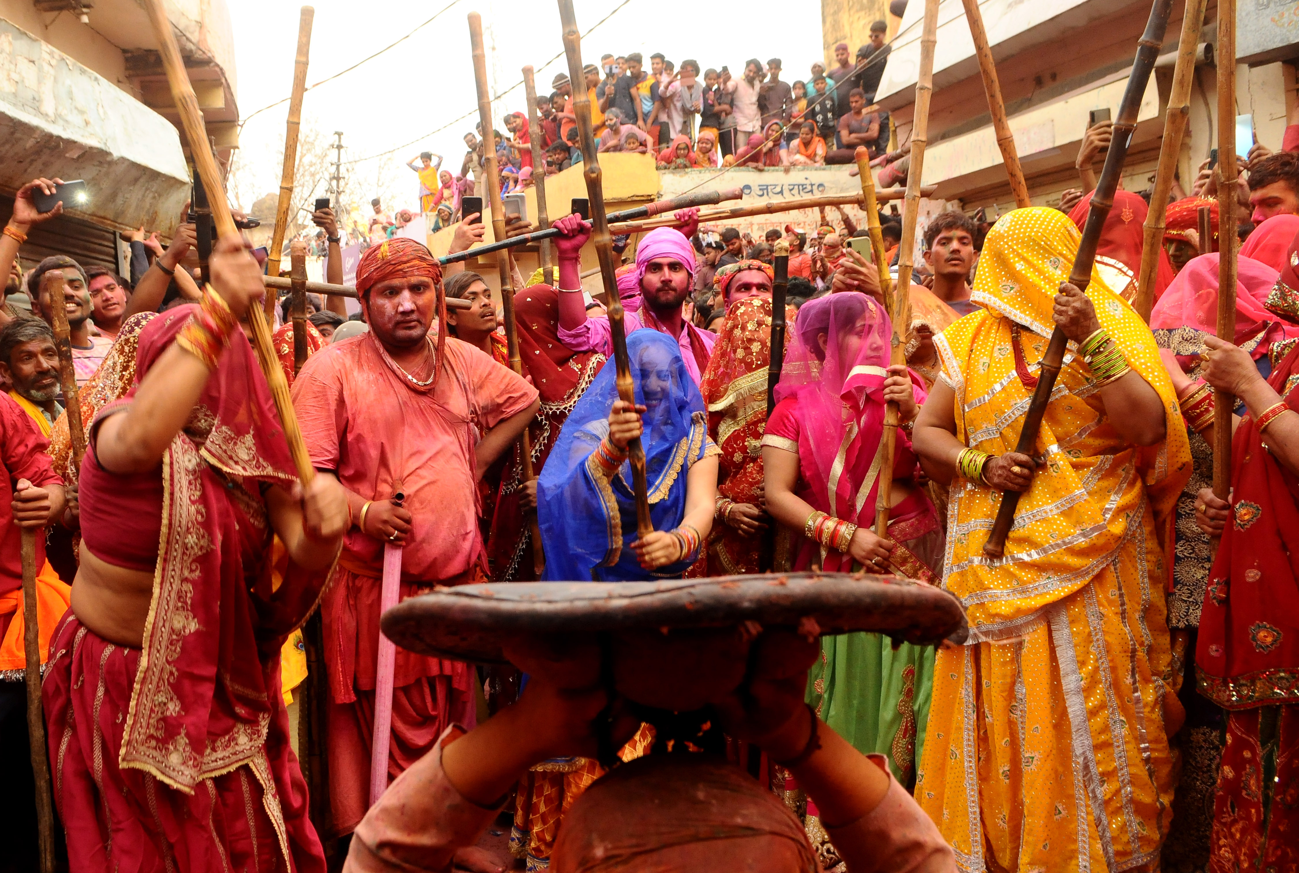 BARSANA, INDIA -MARCH 23, 2021 : Indian women beat men with sticks (lathi) during the Lathmar Holi celebration in the village of Barsana on the outskirts of Mathura in the northern Indian state of Uttar Pradesh, March on India 23,2021 : Imtiyaz Khan  