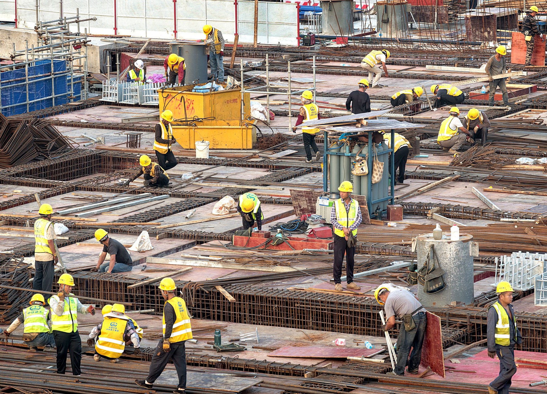 Workers labor at the construction site of a railway station