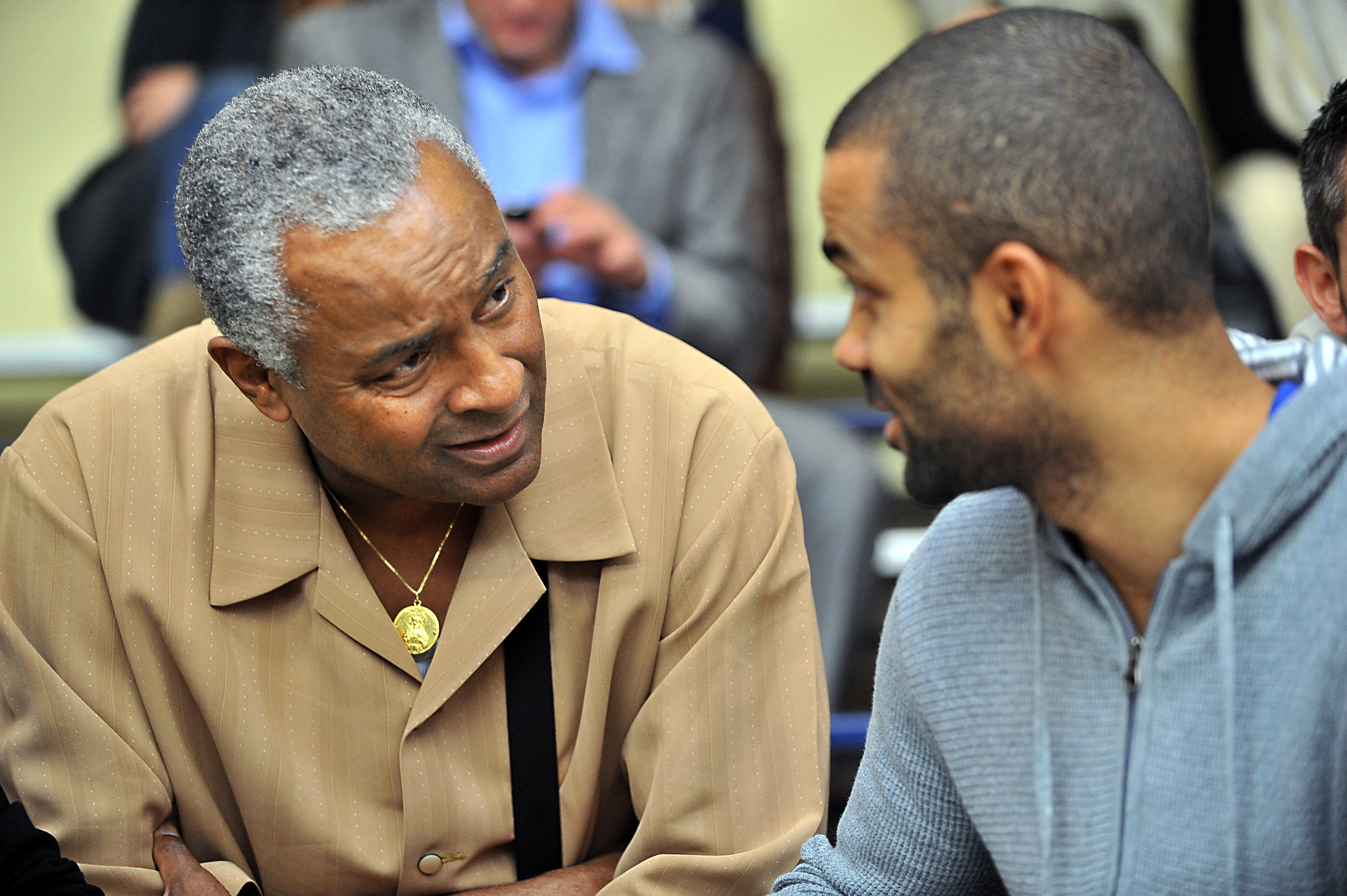 French NBA player Tony Parker (R) speaks with his father before attending the French basket-ball match BC Orchies vs