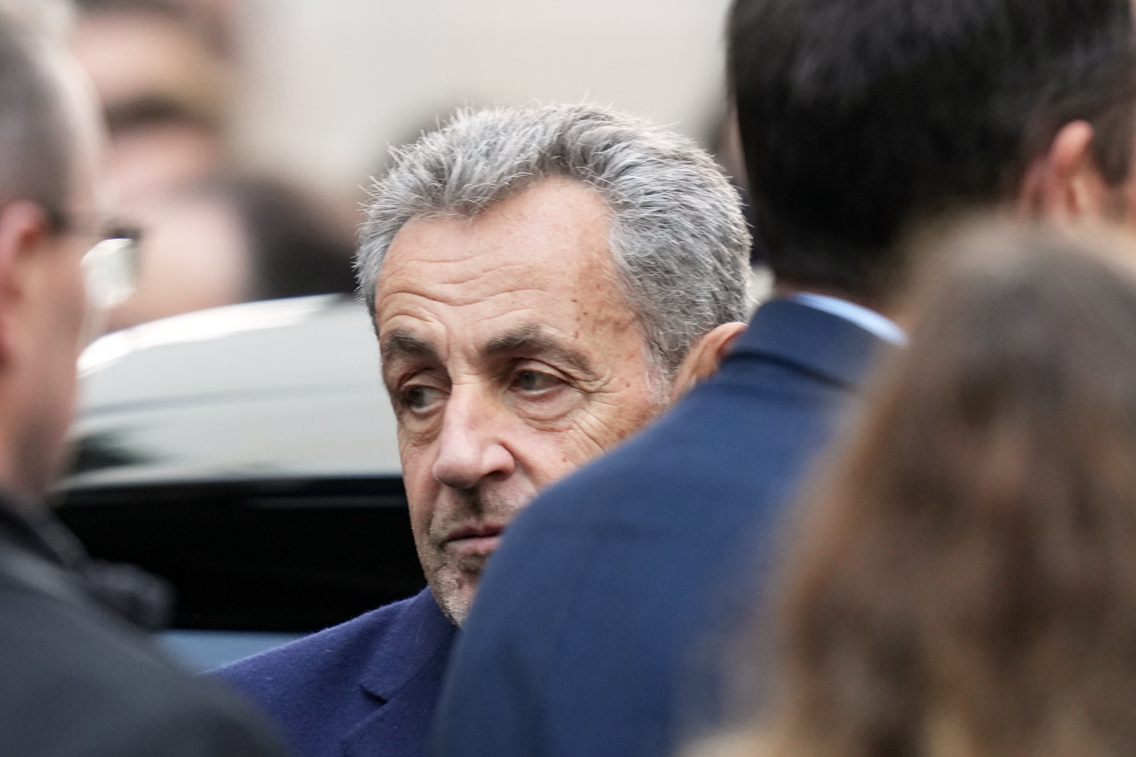 Former French President Nicolas Sarkozy reacts before entering a police car Tuesday, Oct. 21 2025 in Paris as he heads to prison to serve time for a criminal conspiracy to finance his 2007 election campaign with funds from Libya. (AP Photo/Thibault Camus)