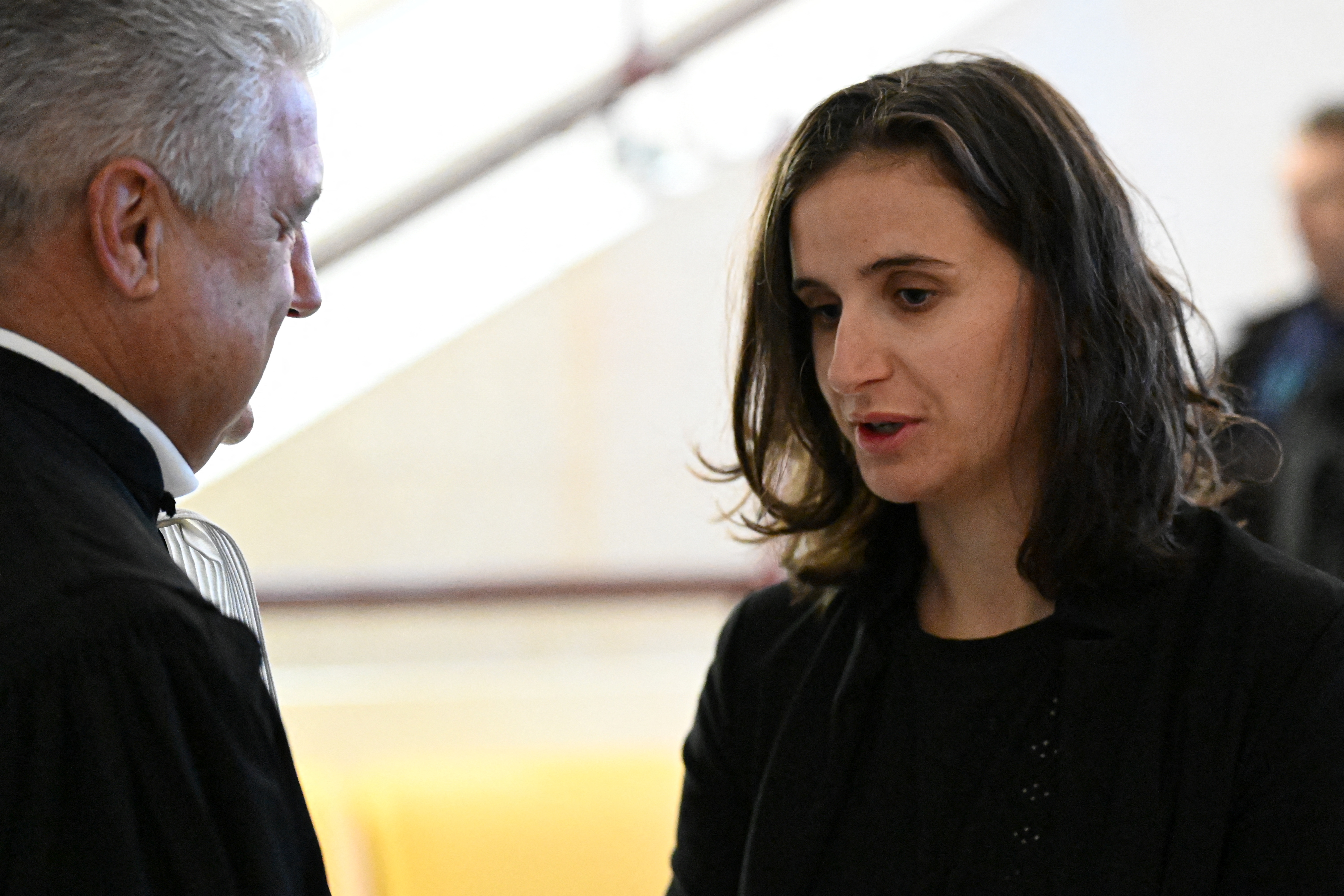 French biathlon champion Julia Simon (R), suspected of credit card fraud, talks with her lawyer, Christian Borel, while she waits for her trial at the Albertville courthouse, on October 24, 2025. (Photo by JEAN-PHILIPPE KSIAZEK / AFP)