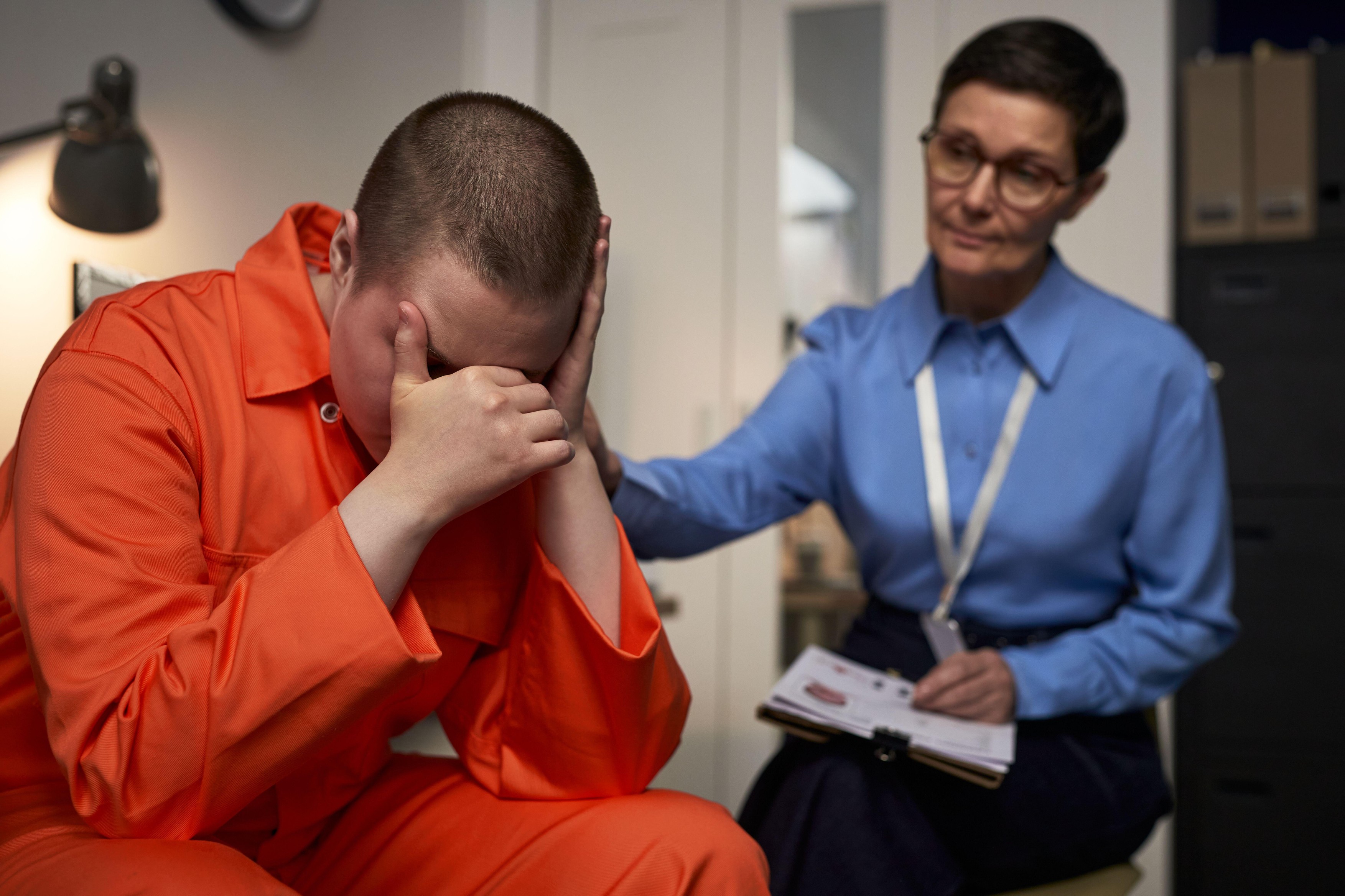Caucasian young adult woman in orange prison uniform
