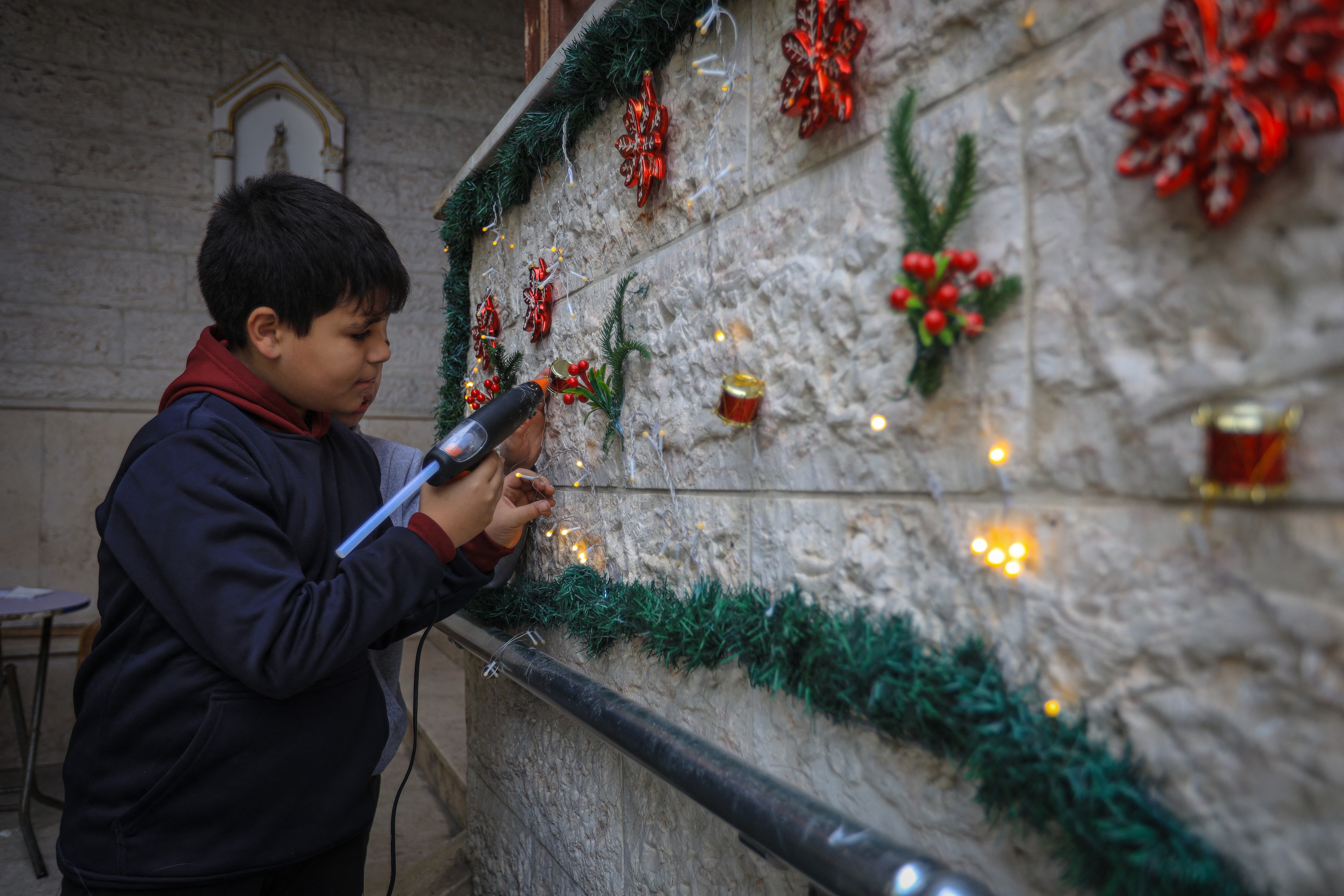 GAZA CITY, GAZA - DECEMBER 9: A boy decorates the wall as Christian Palestinians continue their Christmas preparationsCredit line: AA/ABACA / Abaca Press / Profimedia