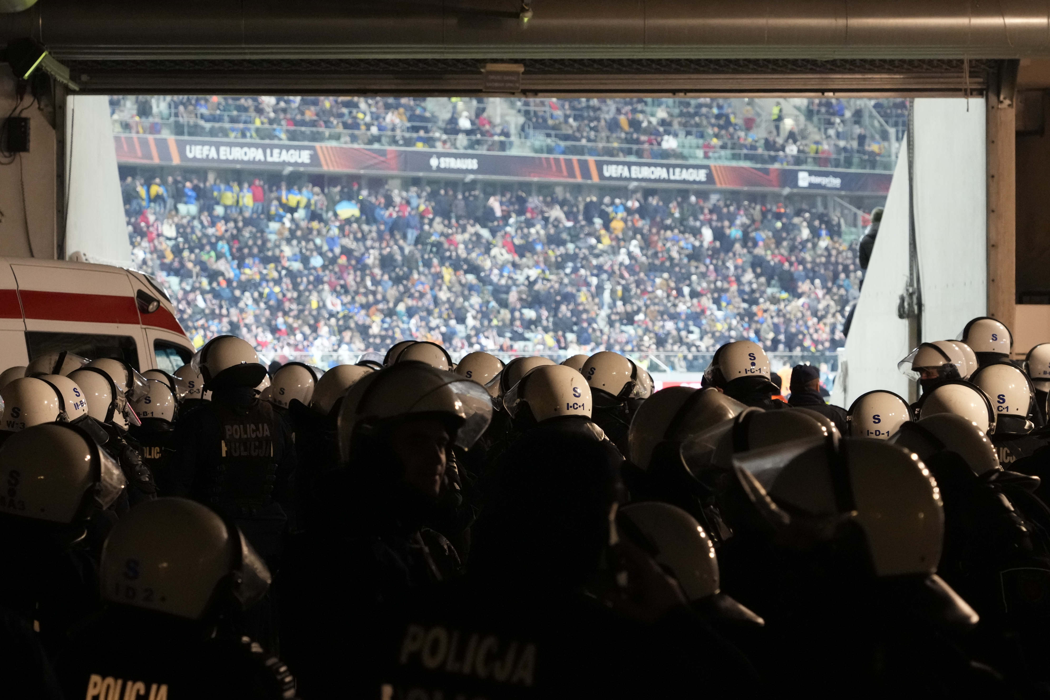 Riot police officers wearing protective gear watch the Europa League round of 16 first leg soccer match between Shakhtar Donetsk and Feyenoord, at Polish Army Stadium in Warsaw, Poland, Thursday, March 9, 2023. (AP Photo/Czarek Sokolowski)