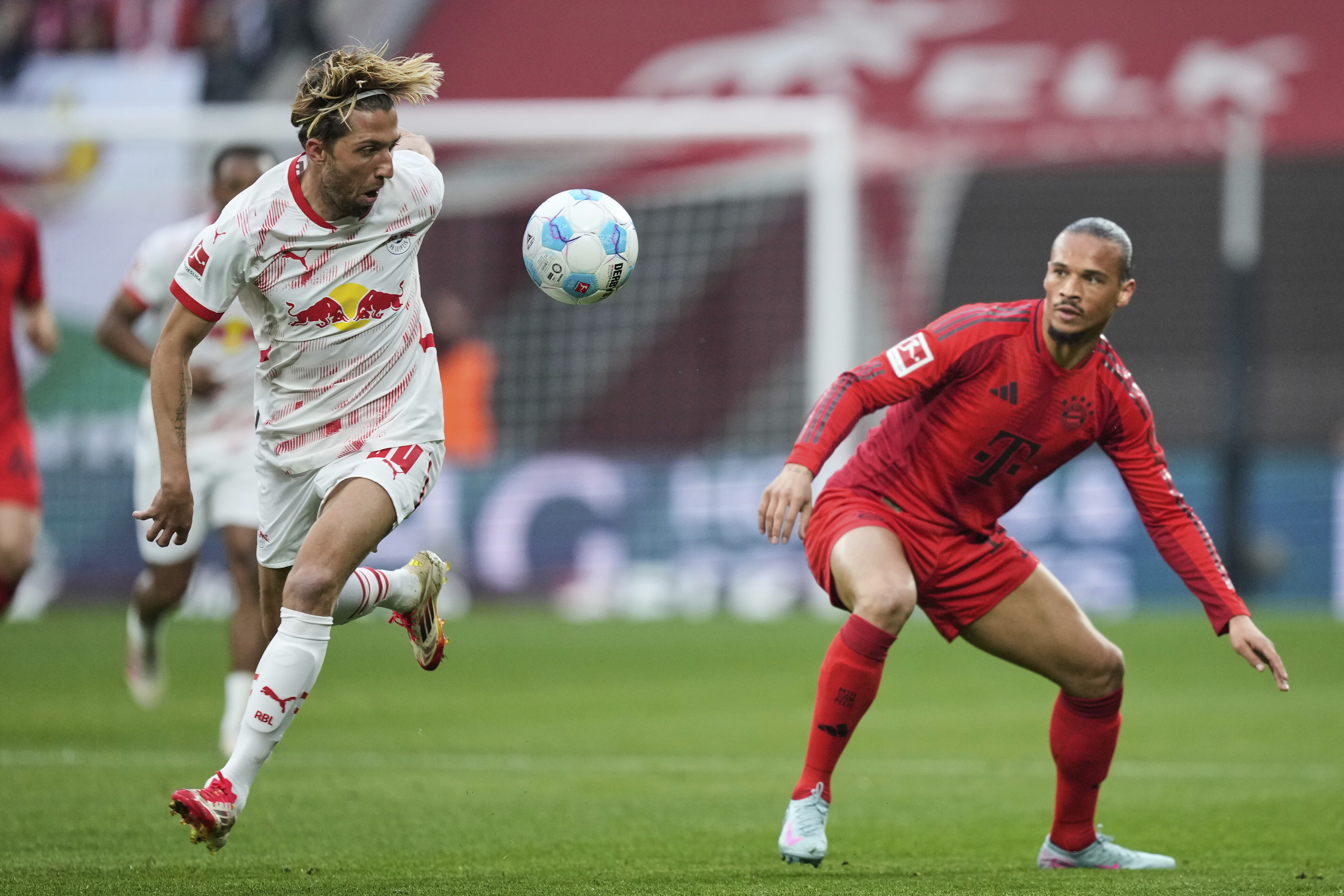 Leipzig's Kevin Kampl, left, challenges for the ball with Bayern's Leroy Sane during the German Bundesliga soccer match between RB Leipzig and FC Bayern Munich at the Red Bull Arena in Leipzig, Germany, Saturday, May 3, 2025. (AP Photo/Ebrahim Noroozi)