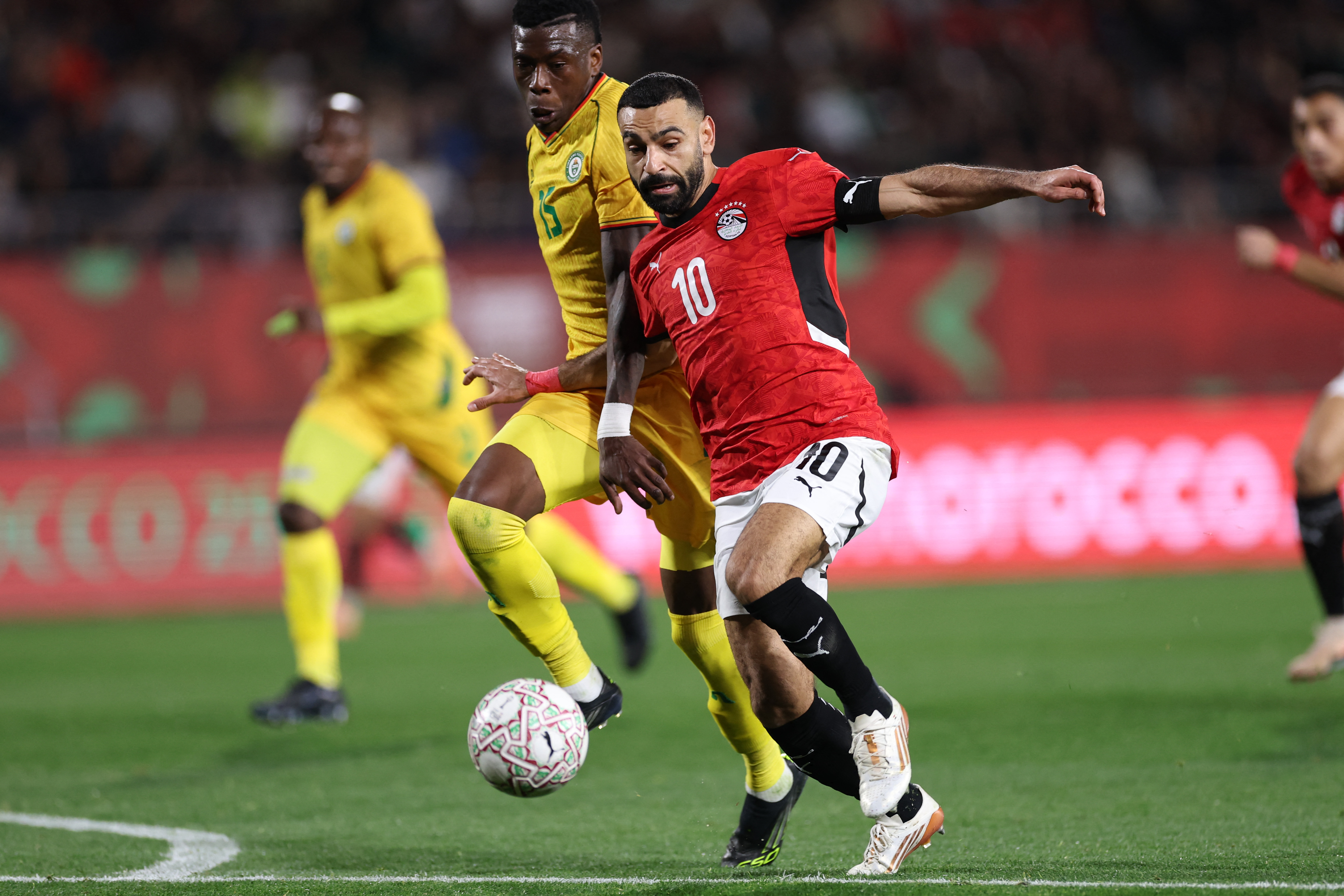 Zimbabwe's defender #15 Teenage Hadebe challenges Egypt's forward #10 Mohamed Salah during the Africa Cup of Nations (CAN) group B football match between Egypt and Zimbabwe at Adrar Stadium in Agadir on December 22, 2025. (Photo by FRANCK FIFE / AFP)