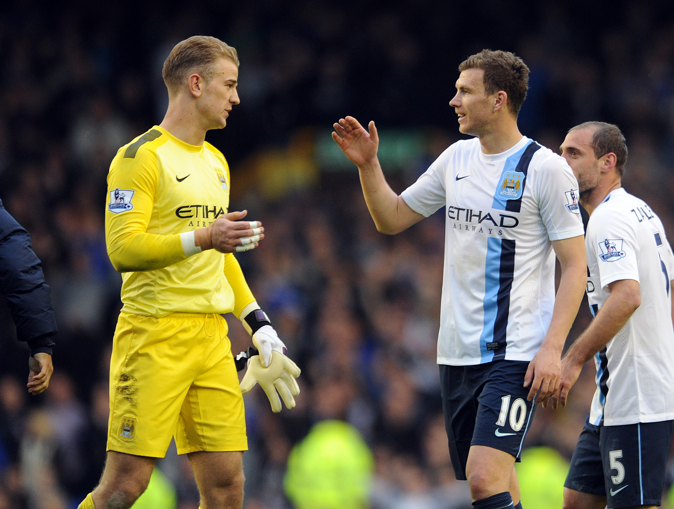 Manchester City's Edin Dzeko right, celebrates his sides victory with teammate Joe Hart after the final whistle during their English Premier League soccer match against Everton at Goodison Park in Liverpool, England, Saturday May 3, 2014. (AP Photo/Clint