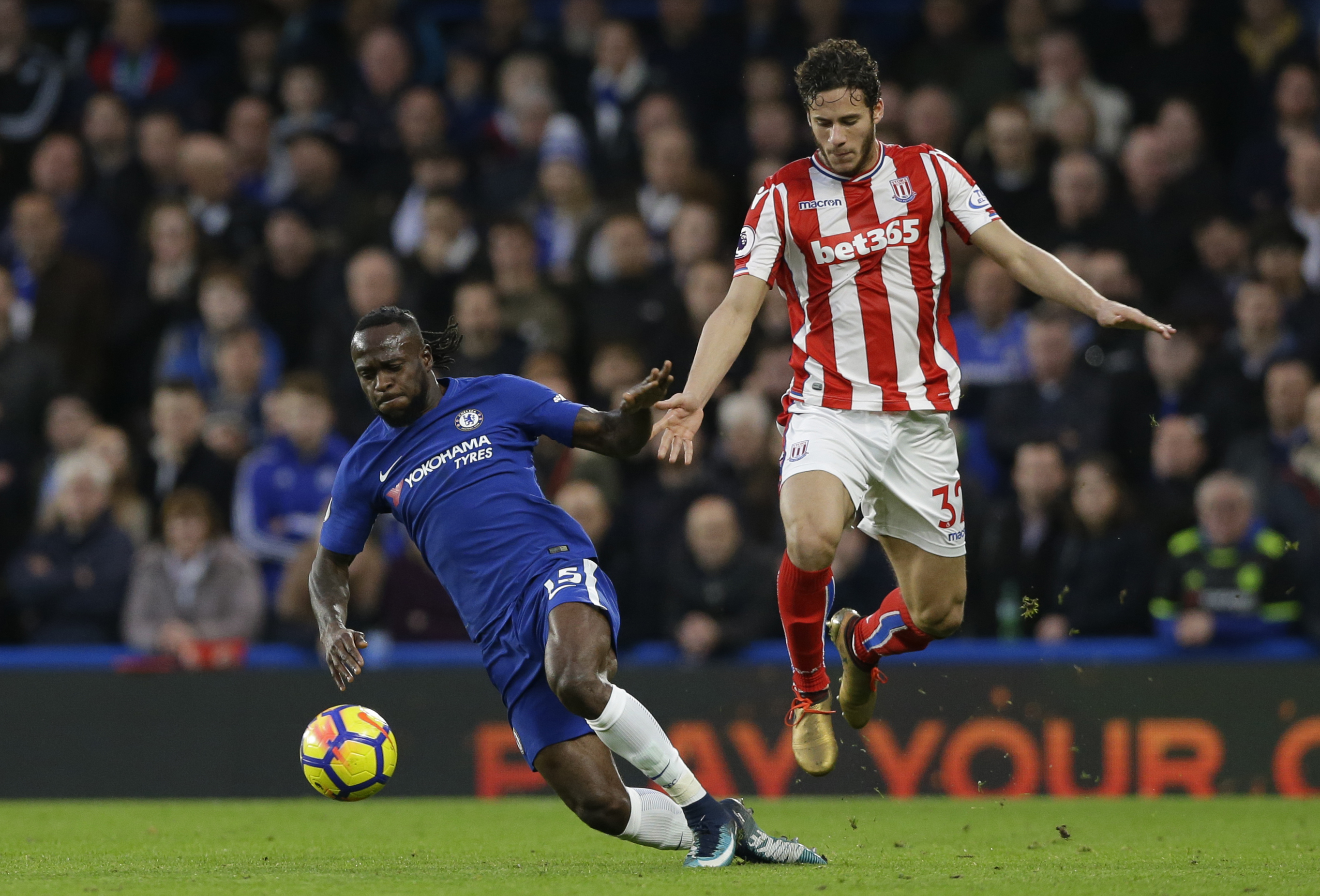 Chelsea's Victor Moses, left, vies for the ball with Stoke City's Ramadan Sobhi during their English Premier League soccer match between Chelsea and Stoke City in London, Saturday, Dec. 30, 2017. Chelsea won the game 5-0. (AP Photo/Alastair Grant)