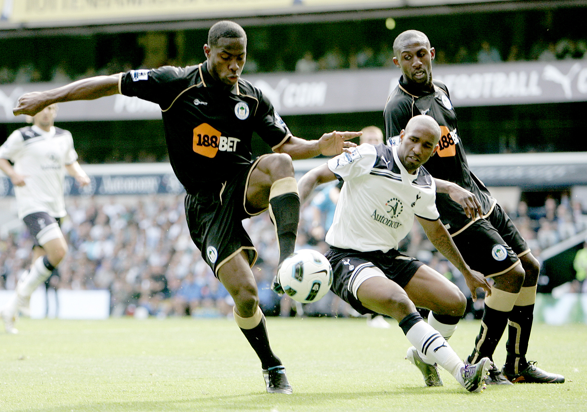 Tottenham Hotspur's Jermain Defoe, center, and Wigan Athletic's Maynor Figueroa, left, vie for the ball during their English Premier League soccer match at White Hart Lane in London, Saturday, Aug. 28, 2010. (AP Photo/Akira Suemori) ** NO INTERNET/MOBILE