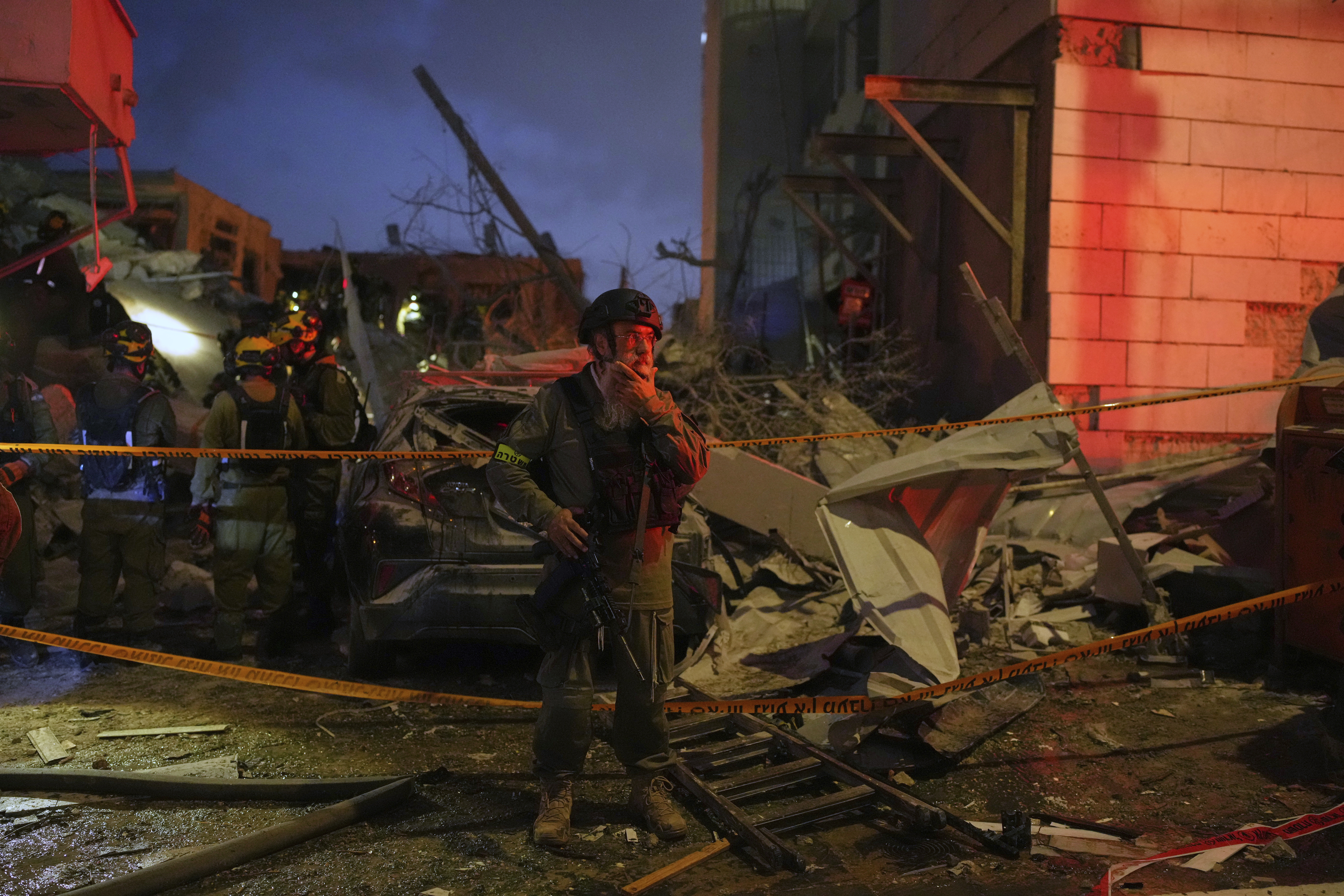 Israeli security forces inspect destroyed buildings that were hit by a missile fired from Iran, near Tel Aviv