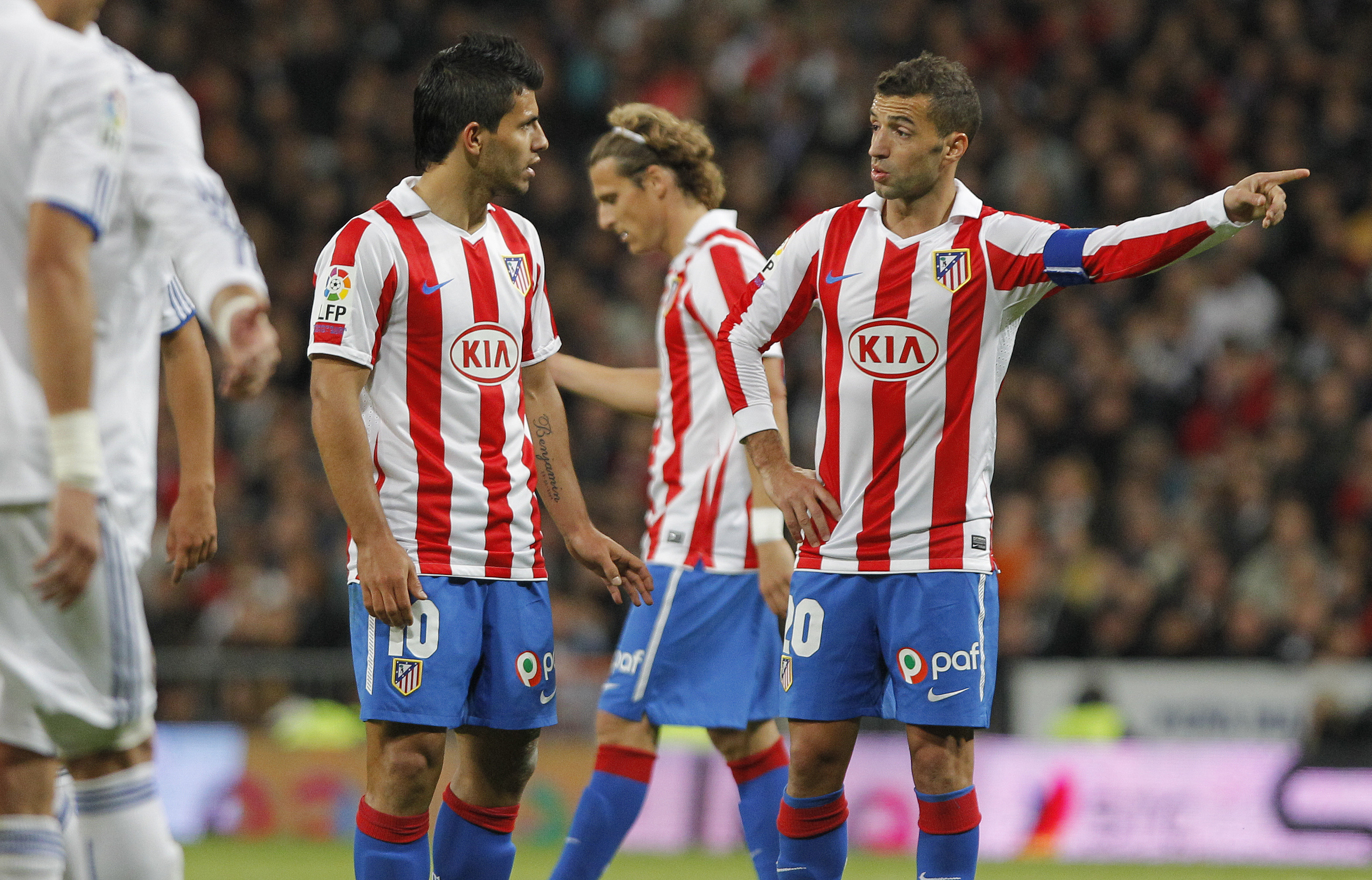 Simao Sabrosa from Portugal, right, Sergio Leonel 'Kun' Aguero from Argentina, left, and Diego Forlan from Uruguay, centre, react during the Spanish La Liga soccer match against Real Madrid at the Santiago Bernabeu stadium i