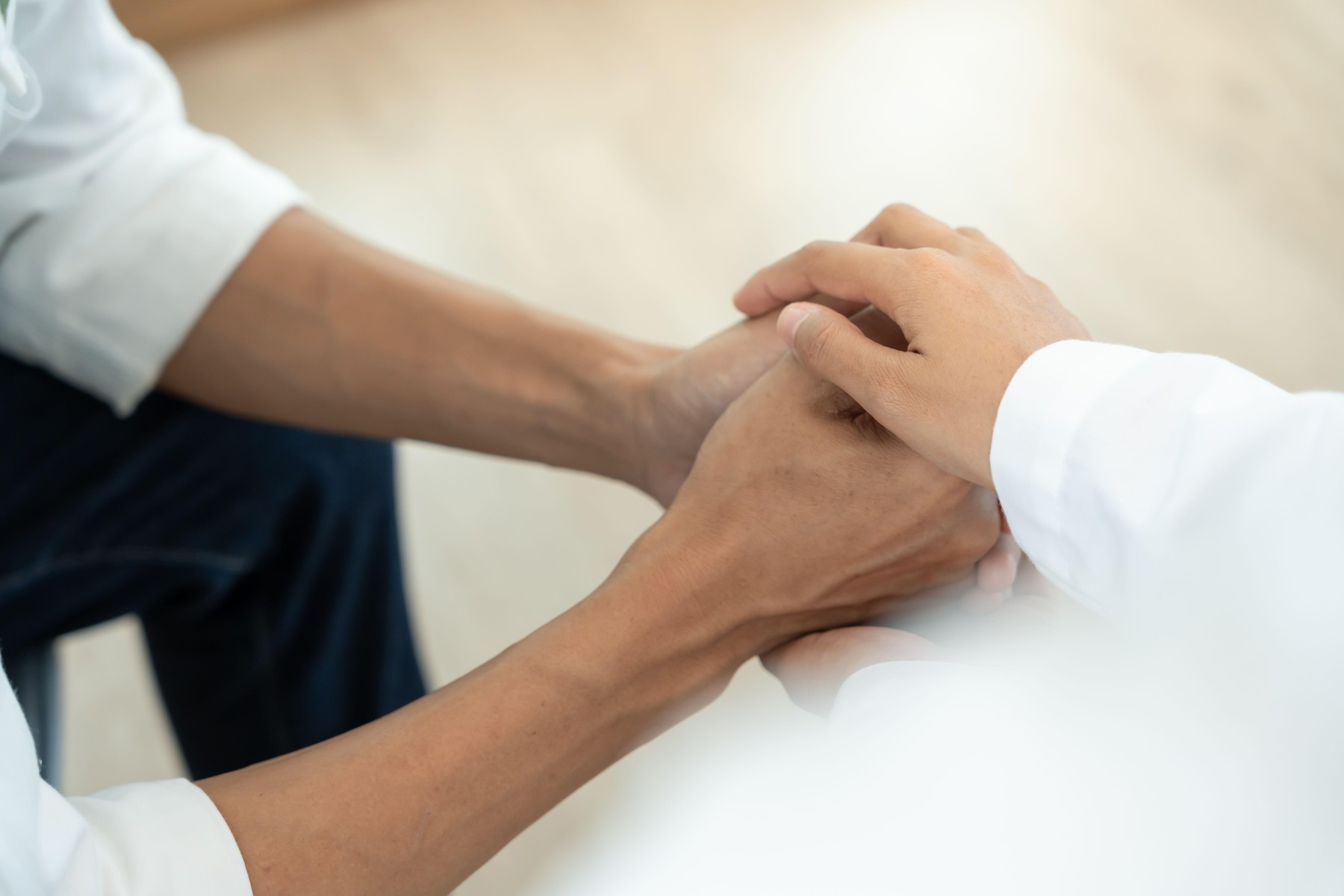 psychiatrist hold hand support each while discussing family issues.