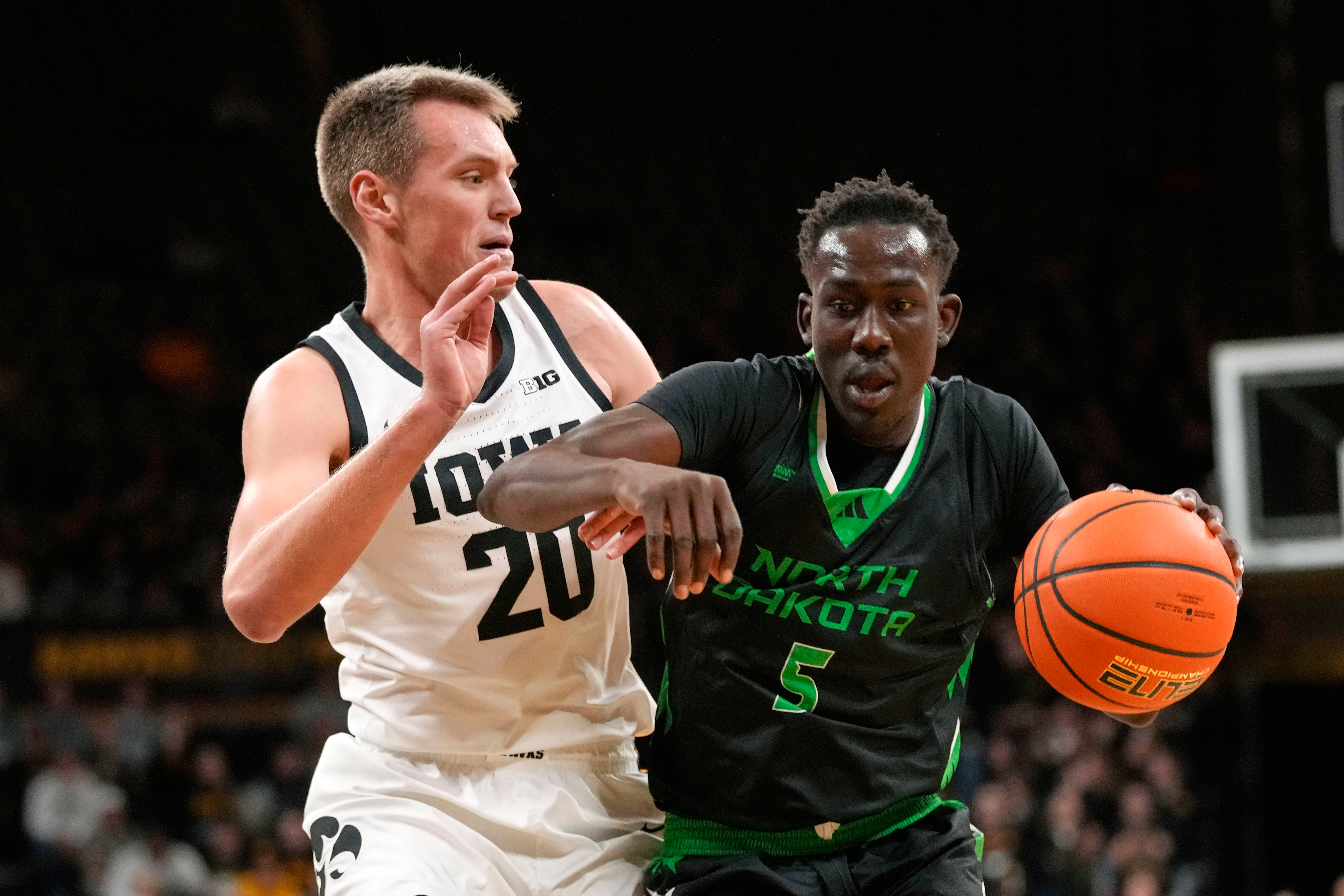 FILE - North Dakota forward Deng Mayar (5) drives past Iowa forward Payton Sandfort (20) during the first half of an NCAA college basketball game, Nov. 7, 2023, in Iowa City, Iowa. (AP Photo/Charlie Neibergall, File)