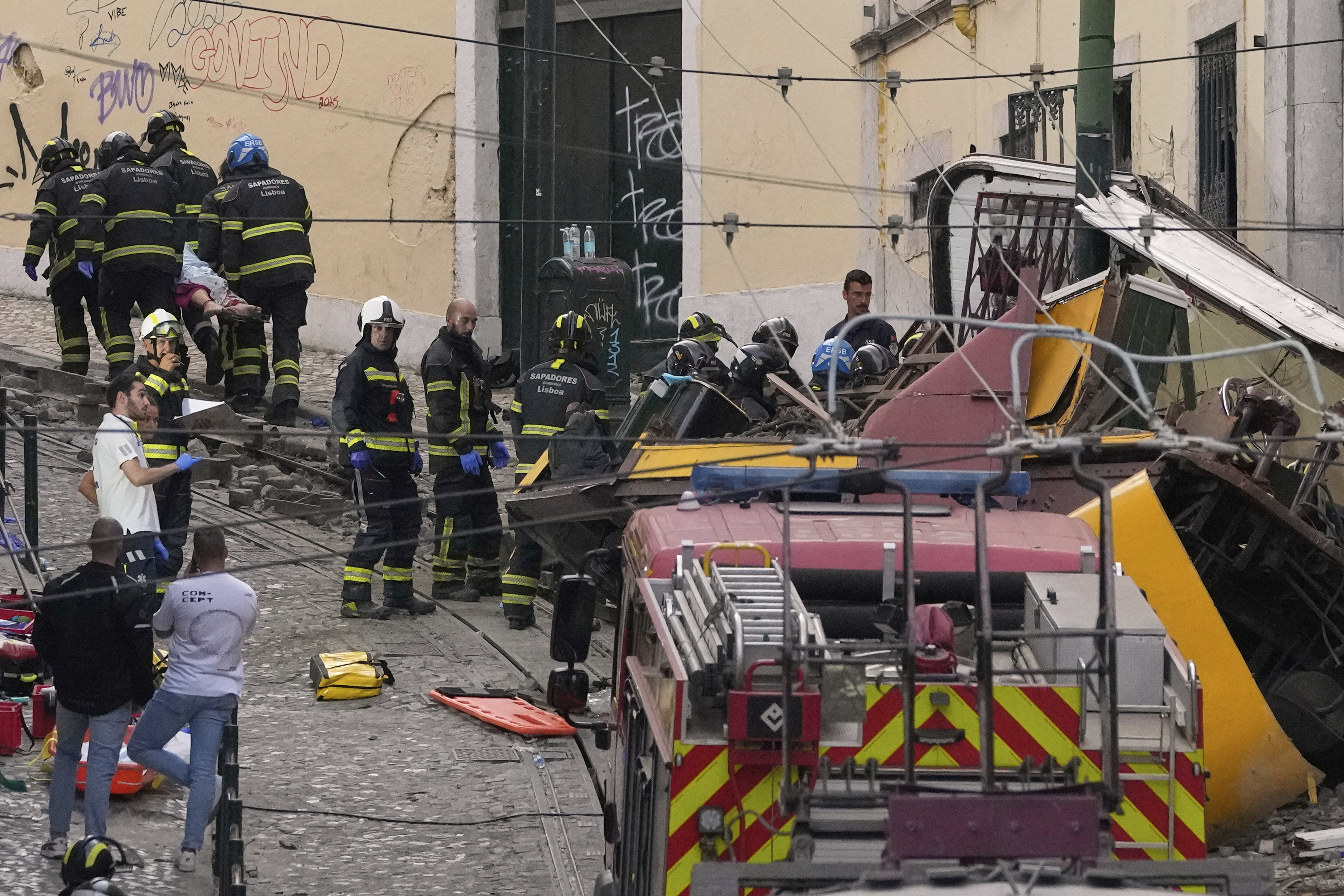 Firefighters carrying the body of a person on a stretcher at the site of a derailed electric streetcar in Lisbon, Portugal, Wednesday, Sept. 3, 2025. (AP Photo/Armando Franca)