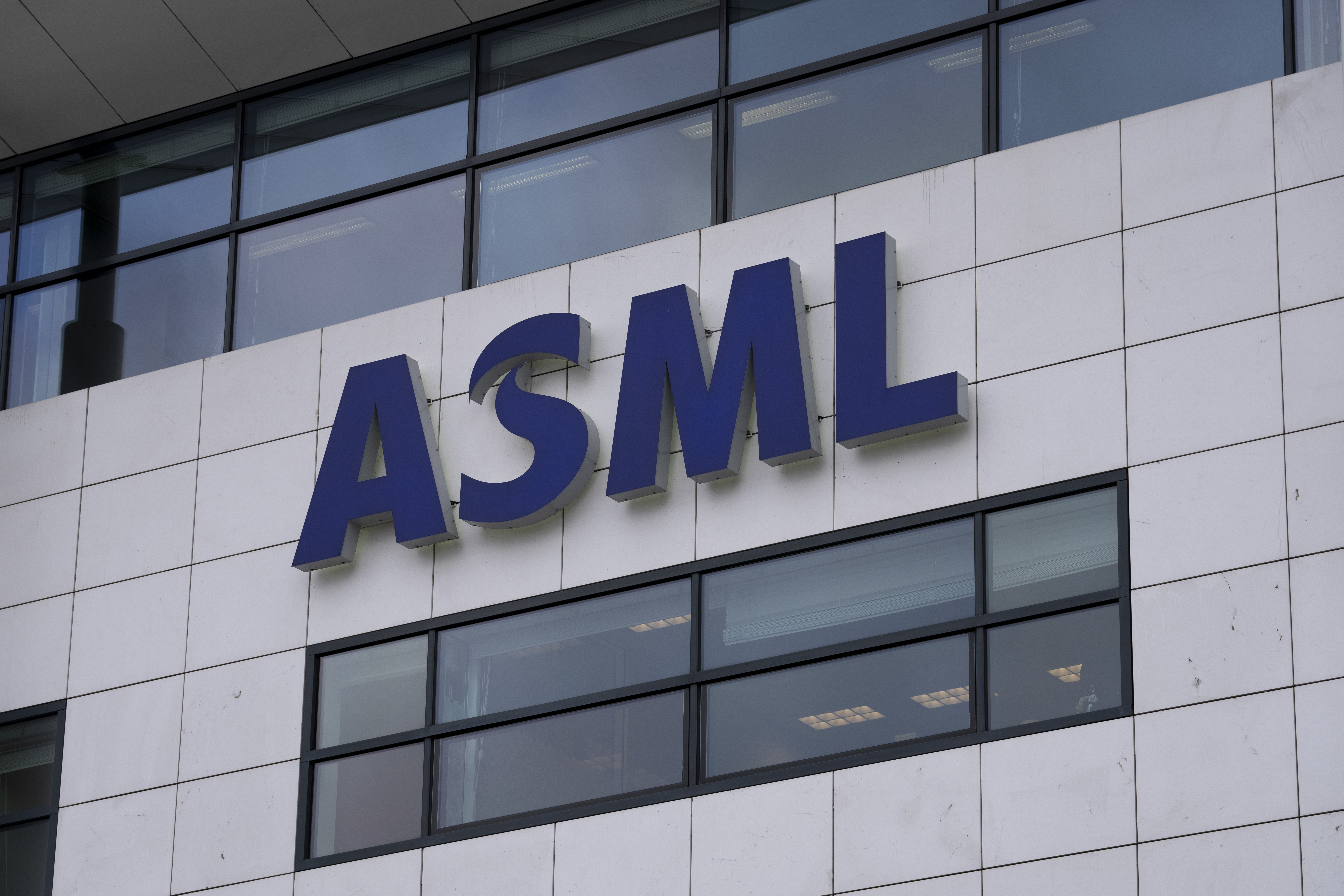 FILE - The logo of ASML, a leading maker of semiconductor production equipment, hangs on the head office in Veldhoven, Netherlands, on Jan. 30, 2023. (AP Photo/Peter Dejong, File)