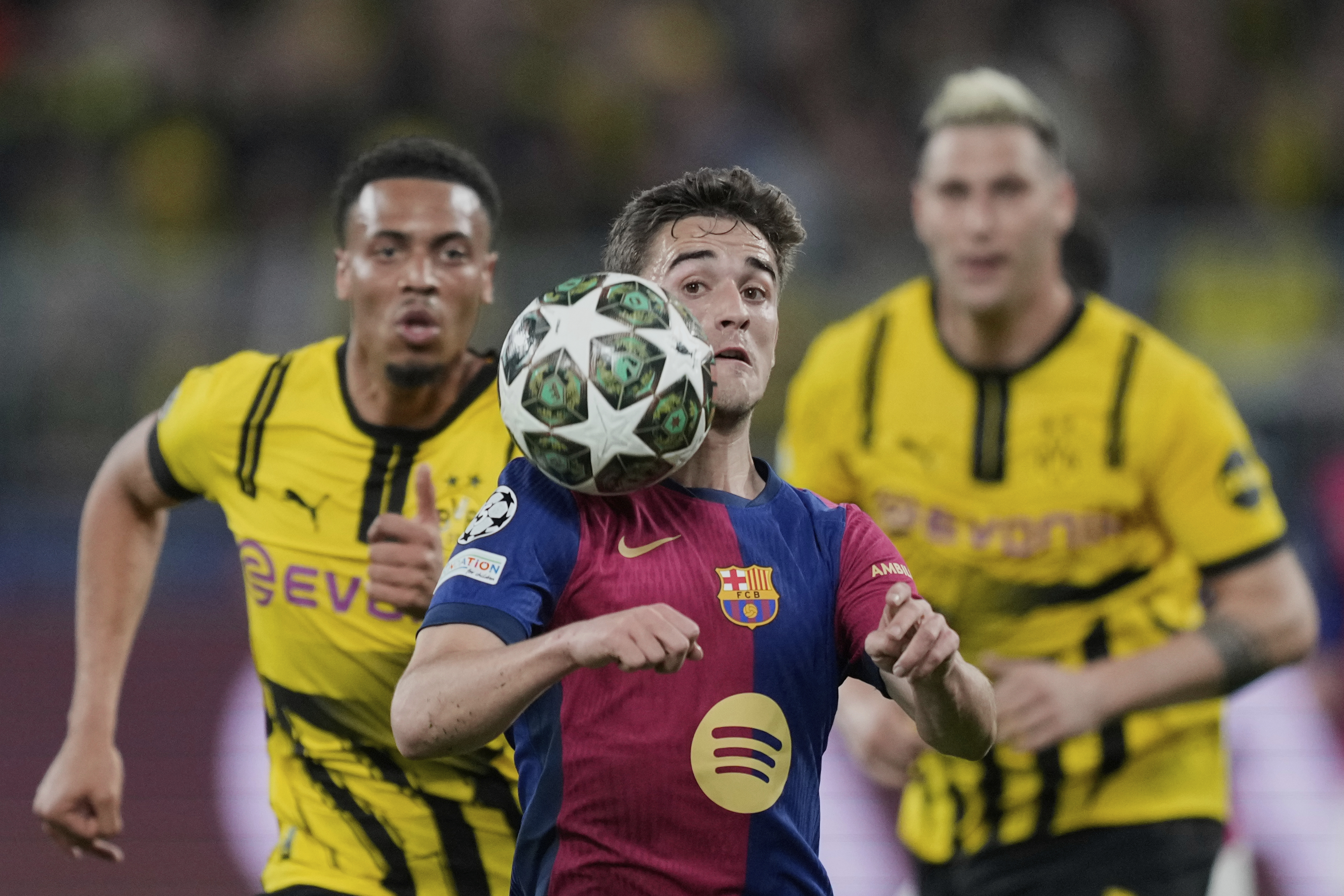 Barcelona's Gavi, center, heads the ball during the Champions League quarterfinals second leg soccer match between Borussia Dortmund and Barcelona, at the Signa-Iduna Park in Dortmund, Germany, Tuesday, April 15, 2025. (AP Photo/Martin Meissner)