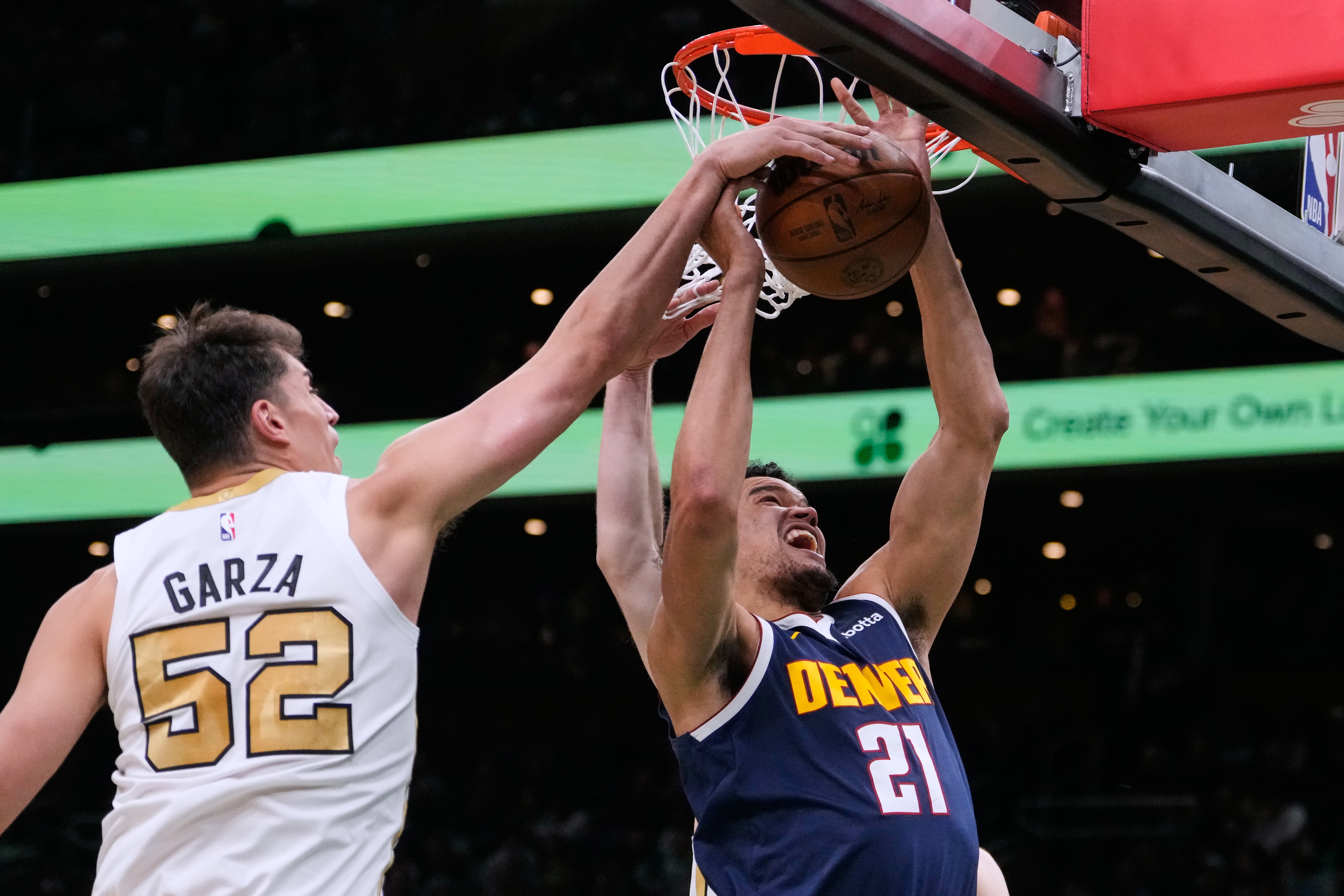Boston Celtics center Luka Garza (52) battles for a rebound against Denver Nuggets forward Spencer Jones (21) during the first half of an NBA basketball game, Wednesday, Jan. 7, 2026, in Boston. (AP Photo/Charles Krupa)