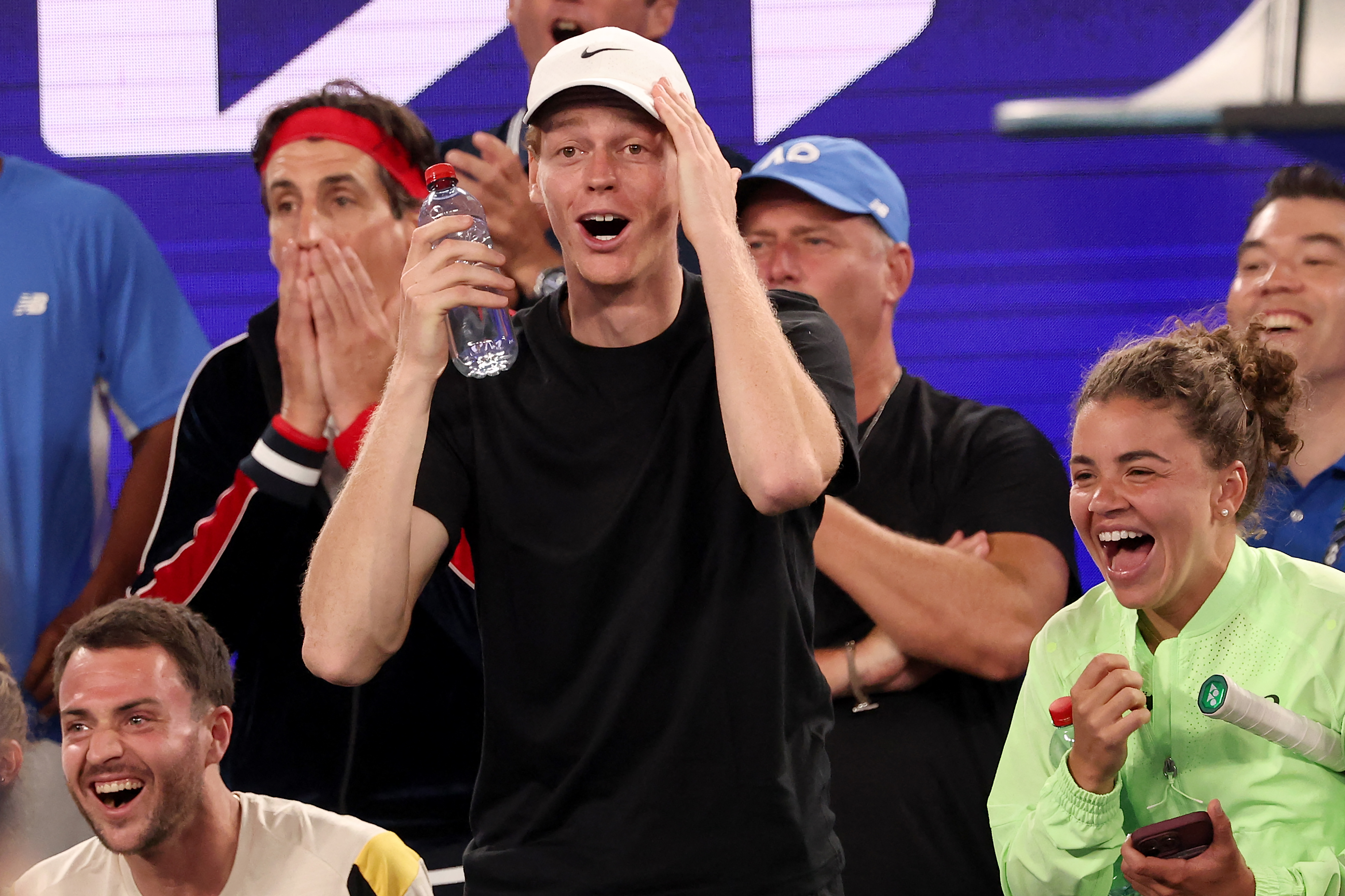 Italy's Jannik Sinner (C) and Jasmine Paolini (R) react during the 1 Point Slam exhibition event ahead of the 2026 Australian Open at Rod Laver Arena in Melbourne on January 14, 2026. (Photo by DAVID GRAY / AFP) / - IMAGE RESTRICTED TO EDITORIAL USE - STR